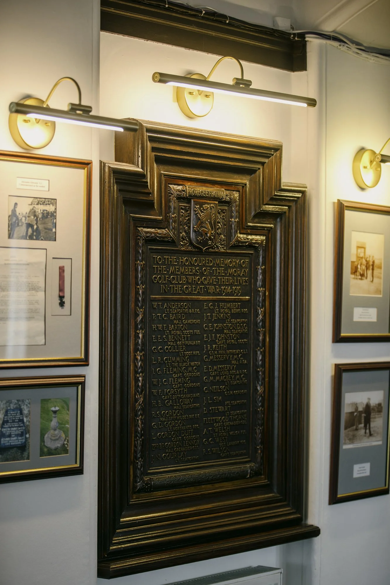 A wooden memorial plaque dedicated to members of a golf club who served in World War I, with a decorative frame and engraved names.