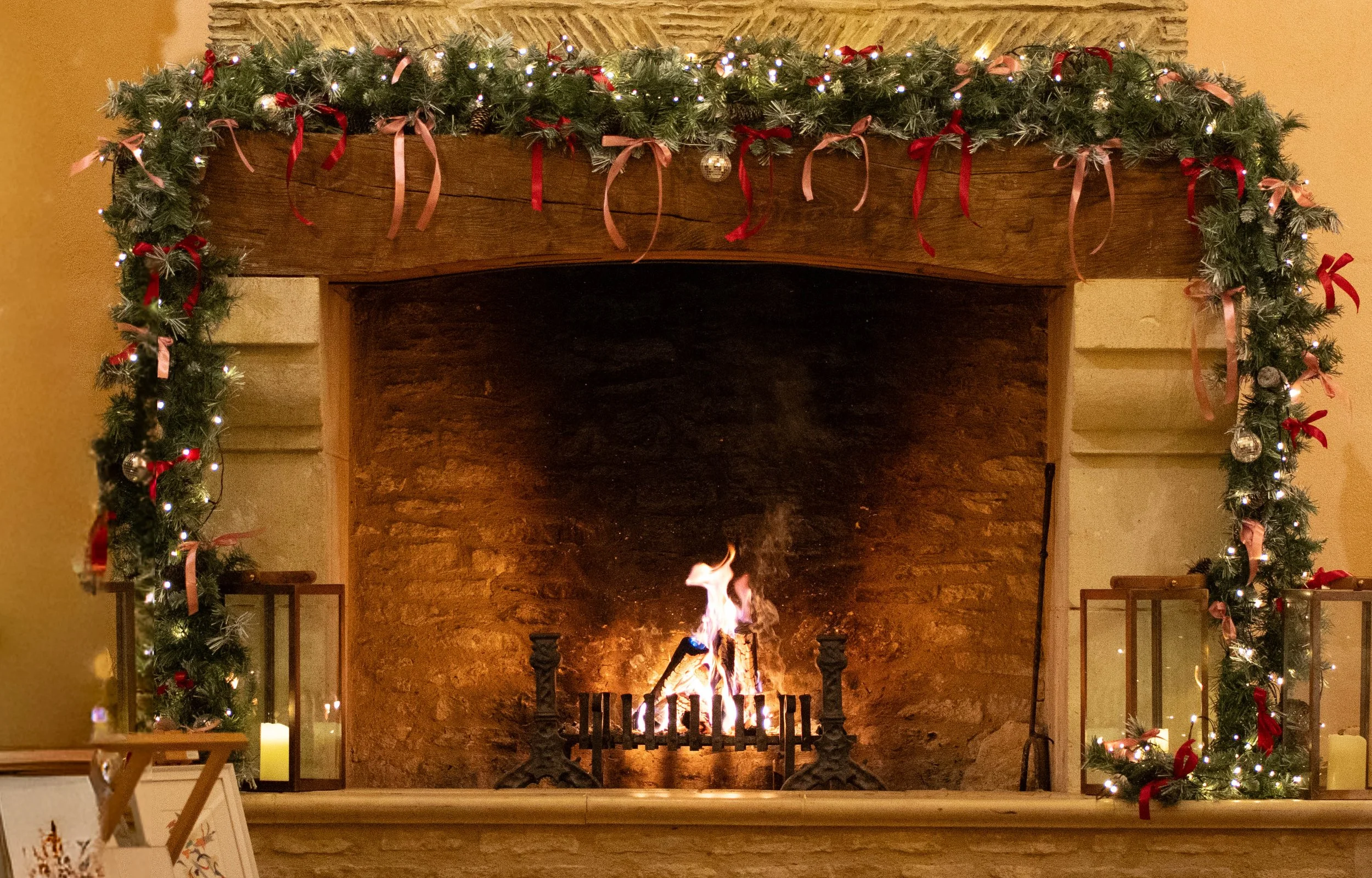 Festive garland and open fire in the barn at Oxleaze, dressed for Christmas