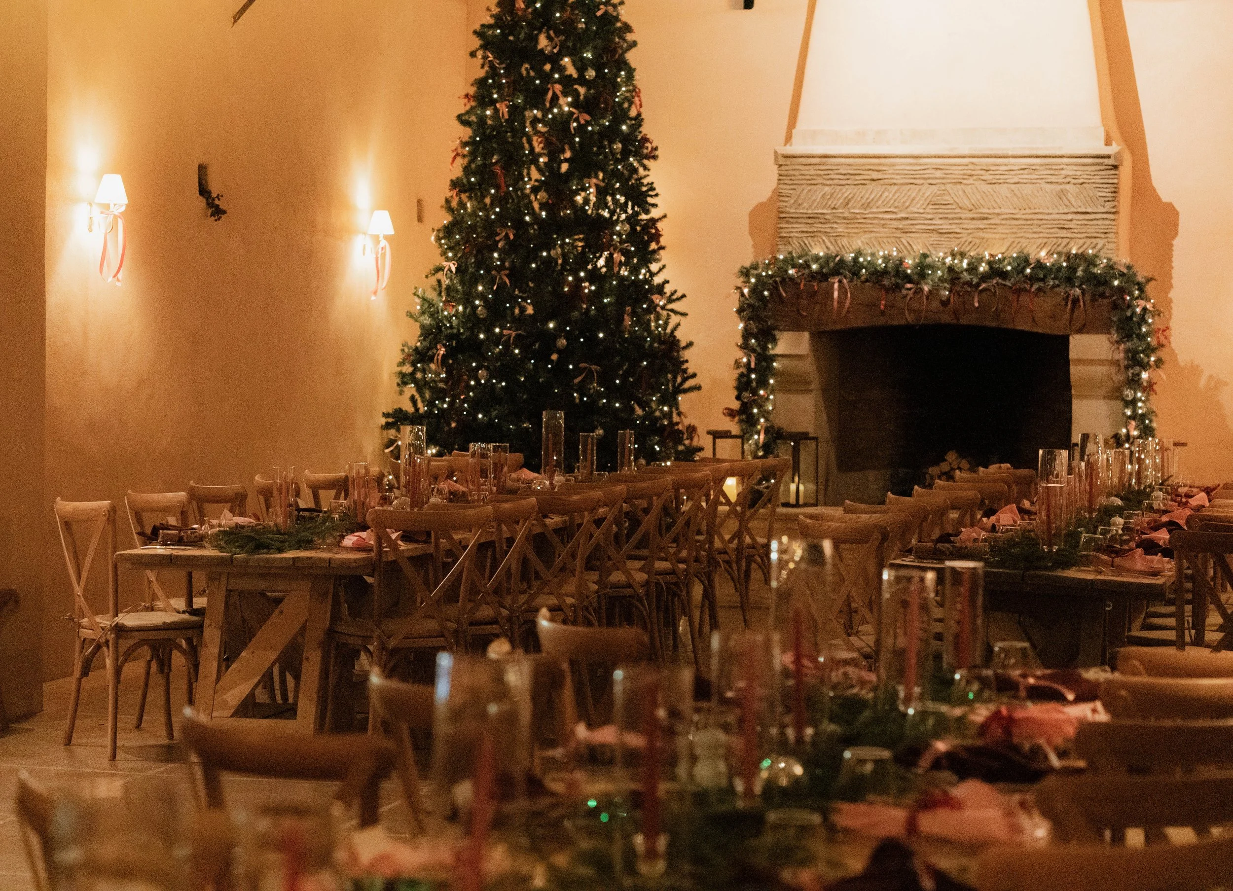 Christmas party dinner set-up with tree and fireplace at Oxleaze Barn, Cotswolds
