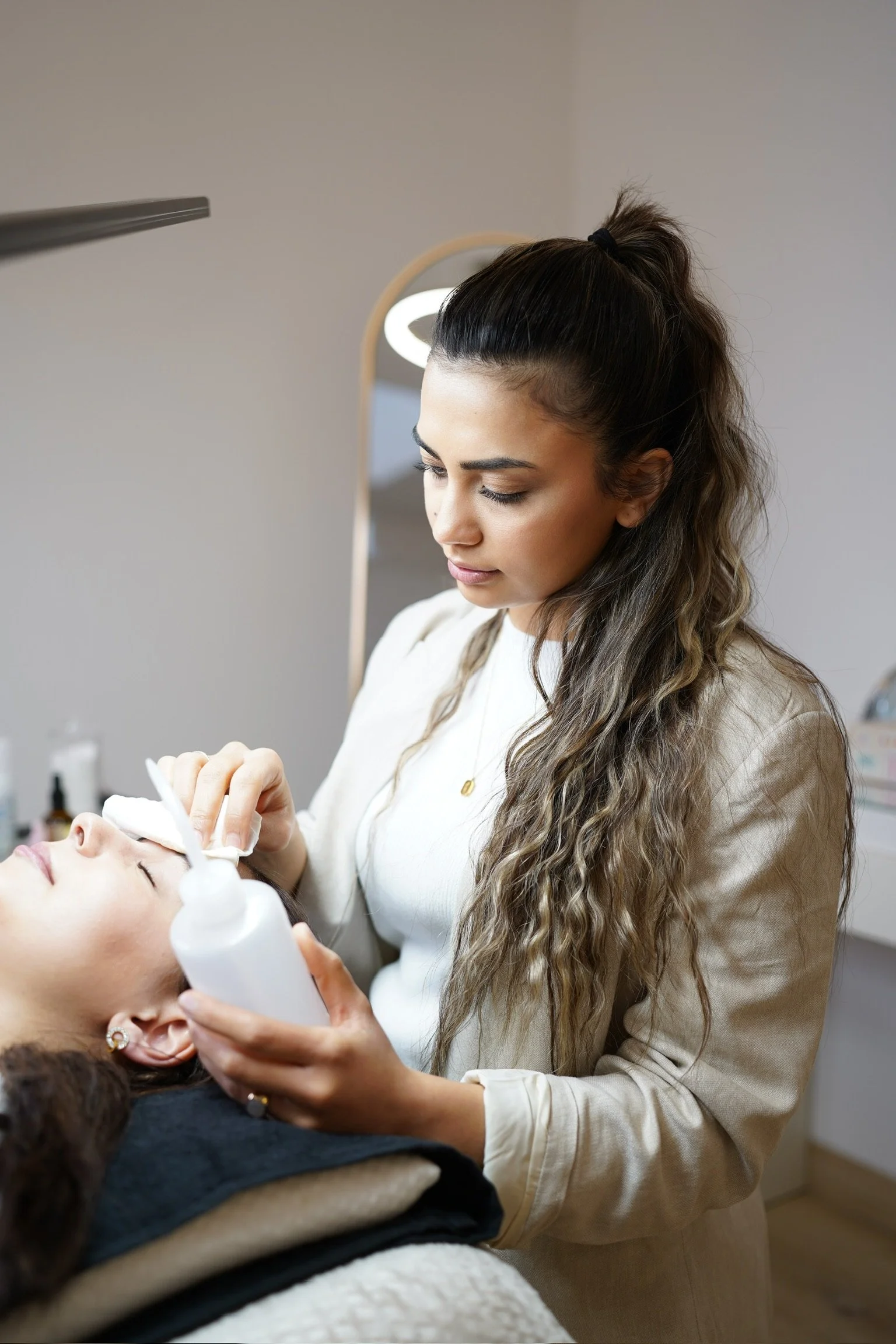 Kosmetikerin führt eine Gesichtsbehandlung bei einer Kundin durch.