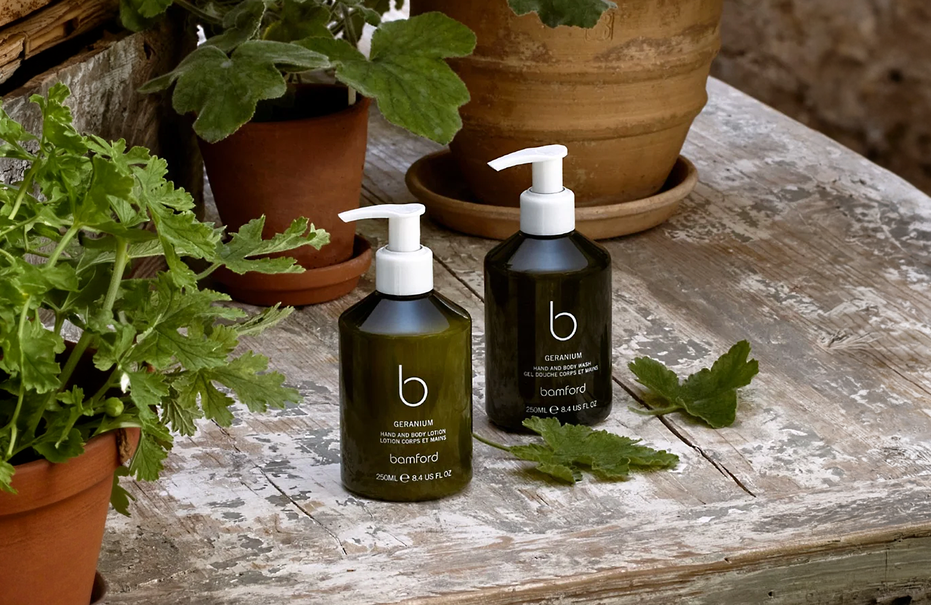 Bamford conscious luxury skincare products with geranium hand lotion, hand cream and body wash, displayed with natural botanicals