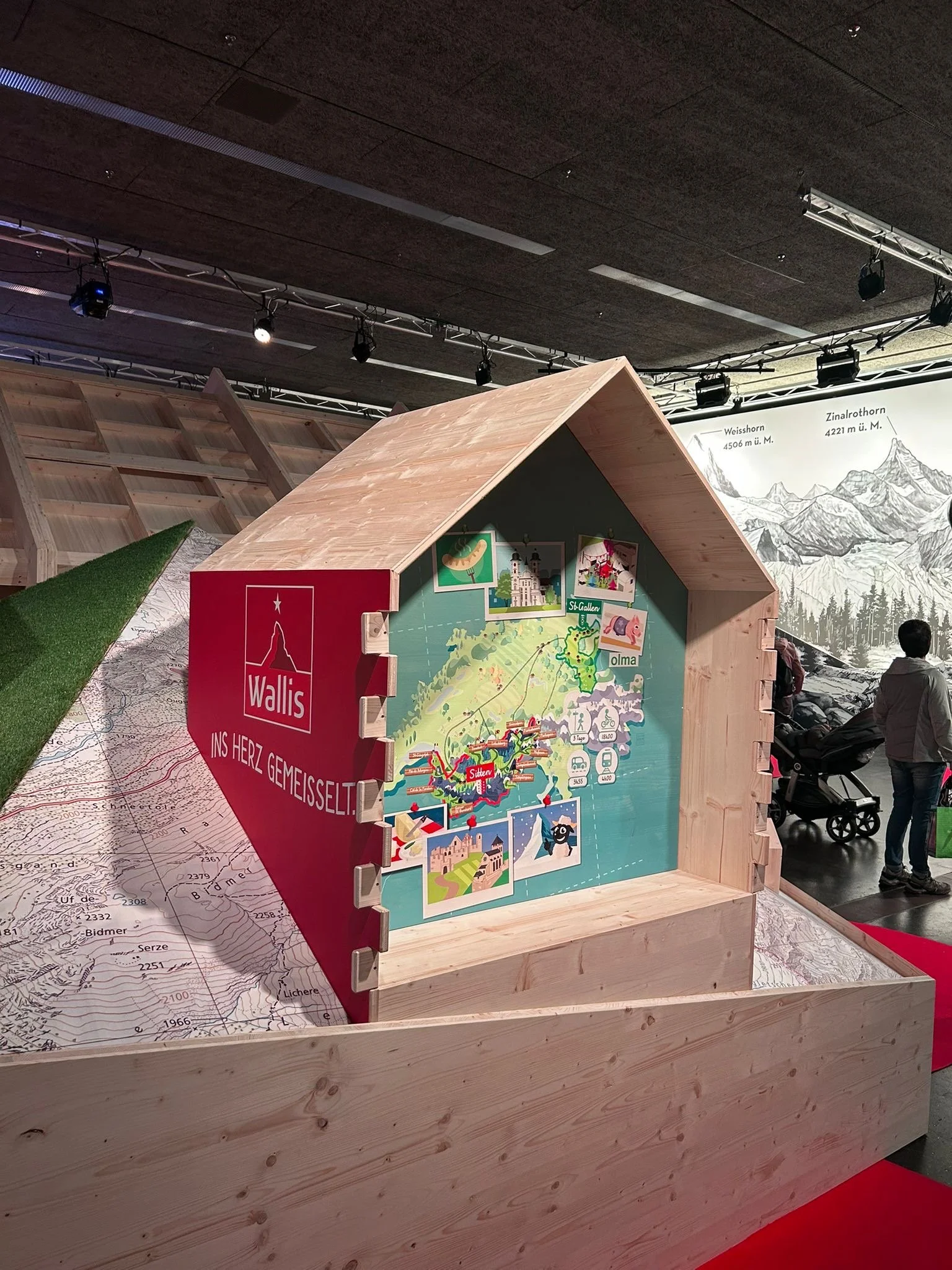 Uen cabane en bois avec à l'intérieur une illustration de Julien Valentini qui repséetne une carte de la Suisse. Le style est frais et jolie.