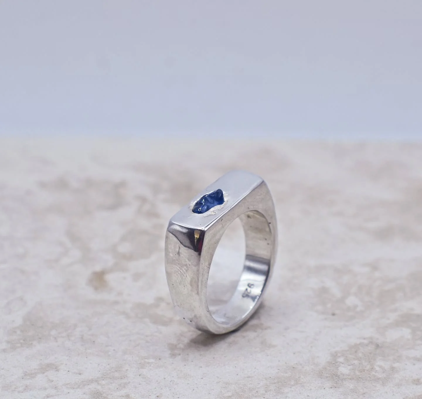 This pebble ring feels like somewhere between minimalism, meets natural, meets polished.
Tumble polished Ceylon sapphire cast in place, and then all the textures filed and sanded out. Finished with a mirror polish.

What do we think folks?