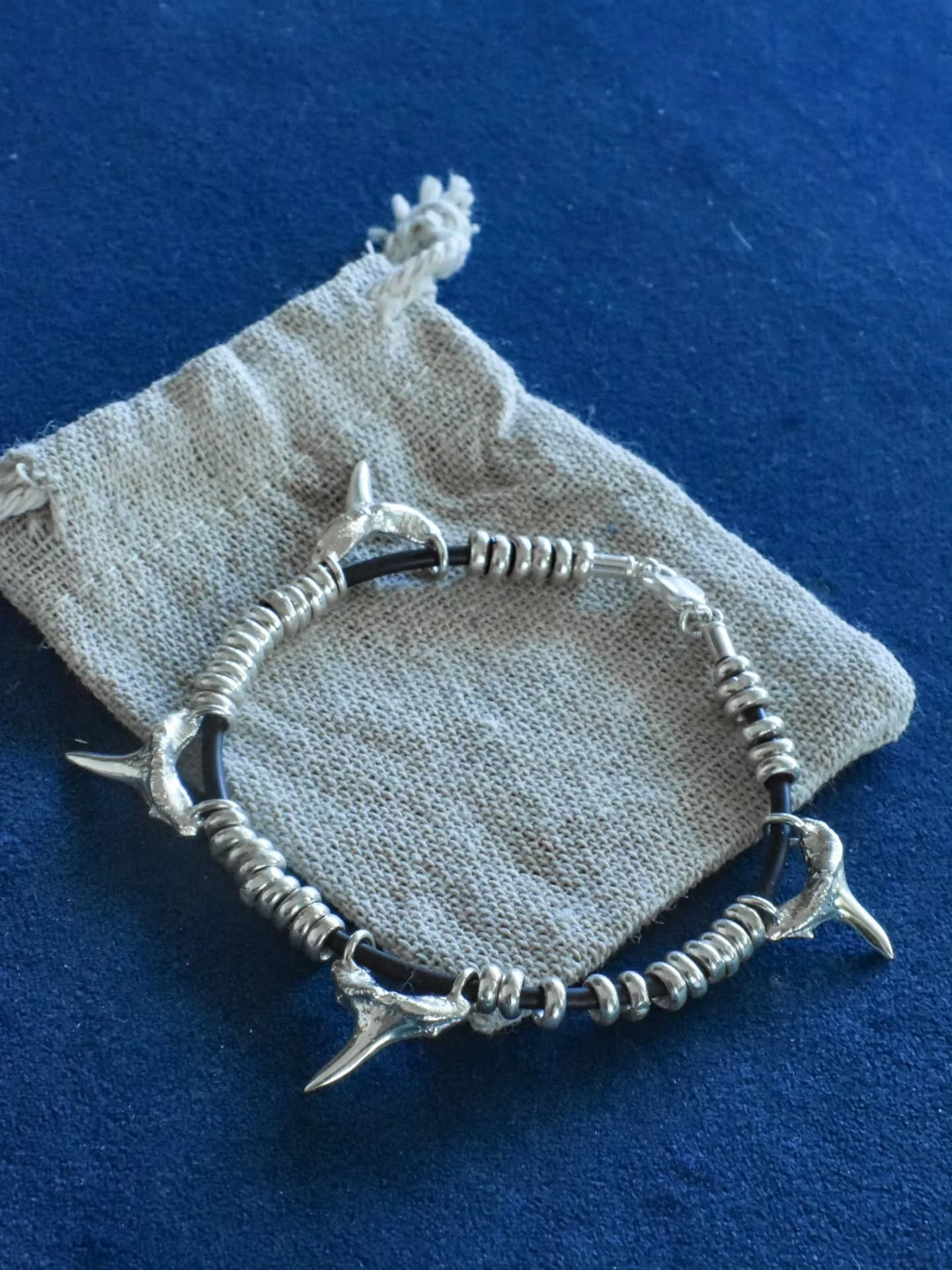 A custom order recently sent off.
Grey nurse shark teeth bracelet consisting of 4 solid silver cast shark teeth. Each tooth represents a family member for the wearer, and a connection to the sea.

In between them are are over 40 little silver ringlet