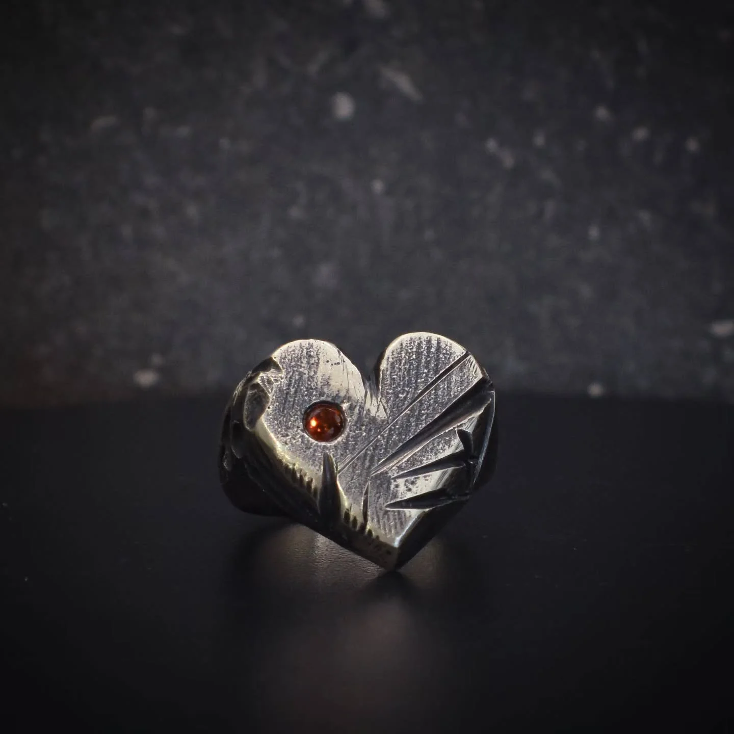 A Kaotic heart ring for all the loverrrs out there.
Much like our own hearts, this ring carries its own battle scars.
A solid sterling silver piece weighing in at a chunky 16g, and featuring a stunning 3mm orange lab sapphire.

Oh, did I mention its 