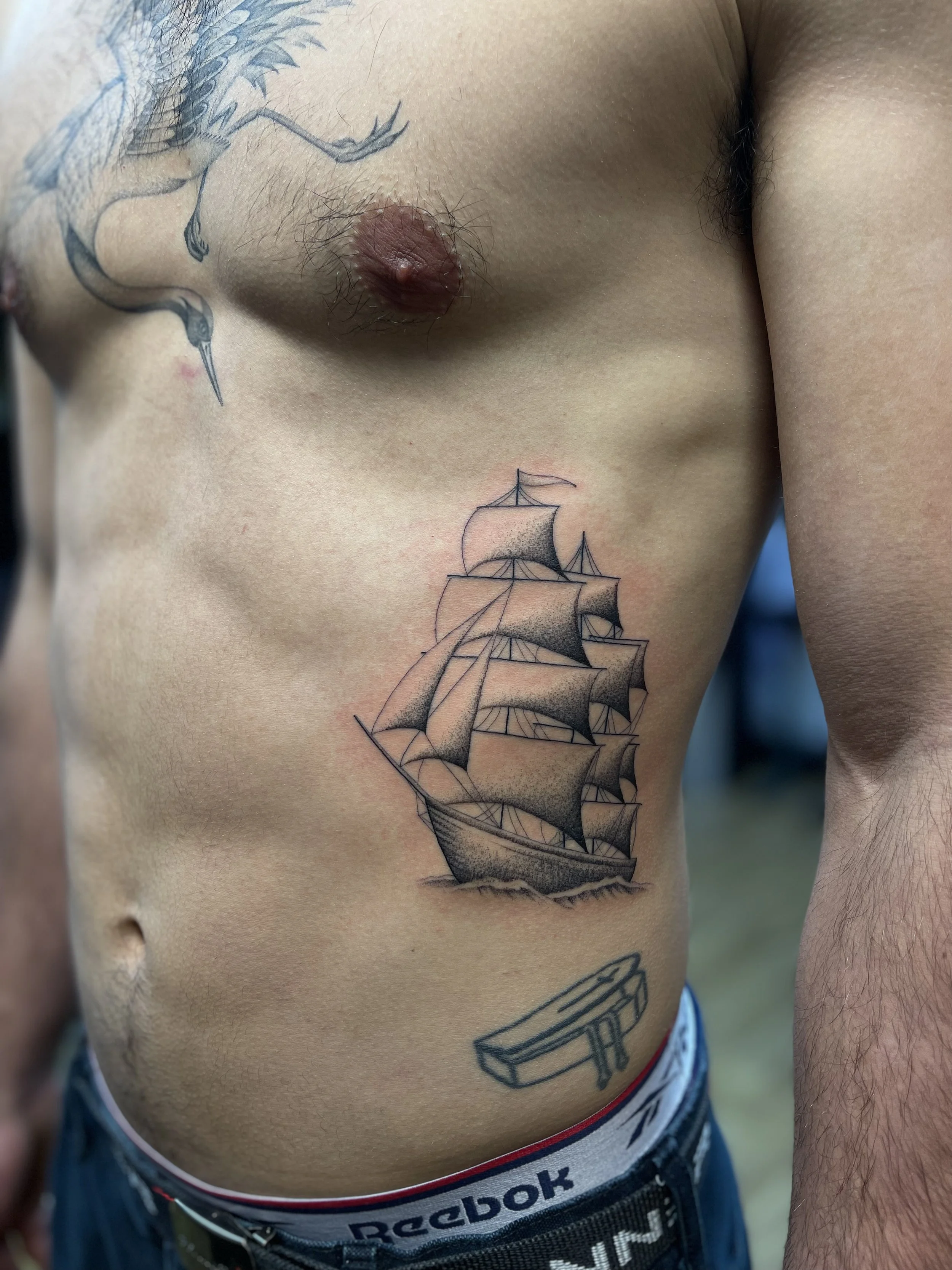 Fine line, single needle ship tattoo on the ribs, done at Frith Street Tattoos, Soho, central London.