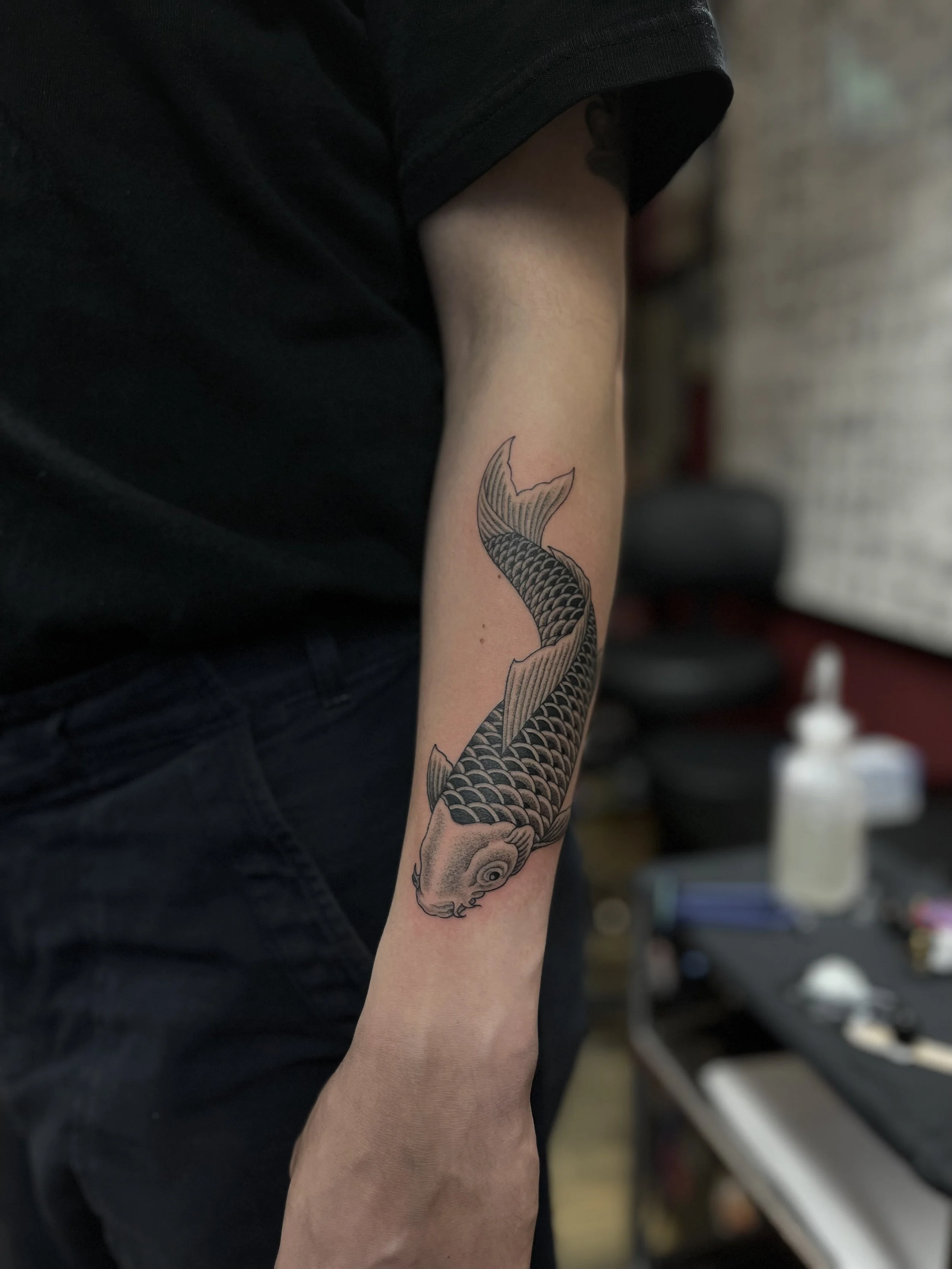 Fine line Japanese koi tattoo on the forearm, done at Frith Street Tattoos, Soho, central London.