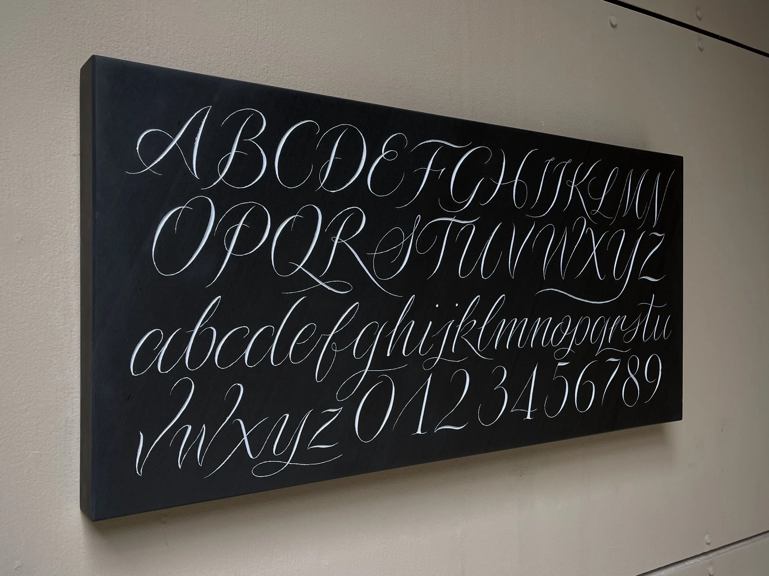 Alphabet and numbers in slate, carved by hand and painted.