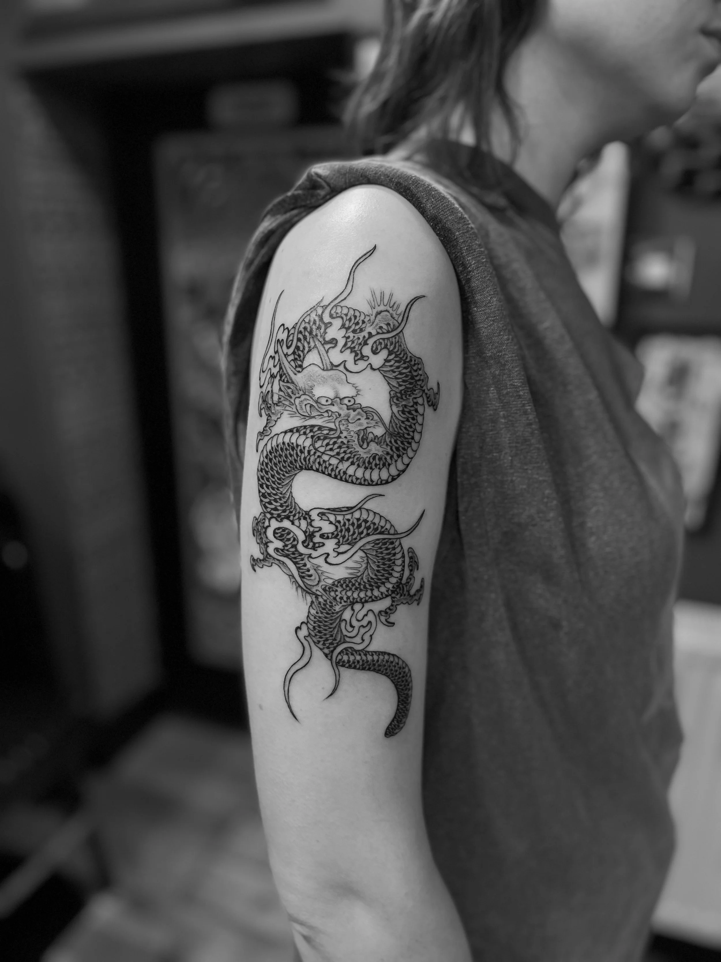Fine line b&g dragon on the upper arm, done at Frith Street Tattoos, Soho, central London.