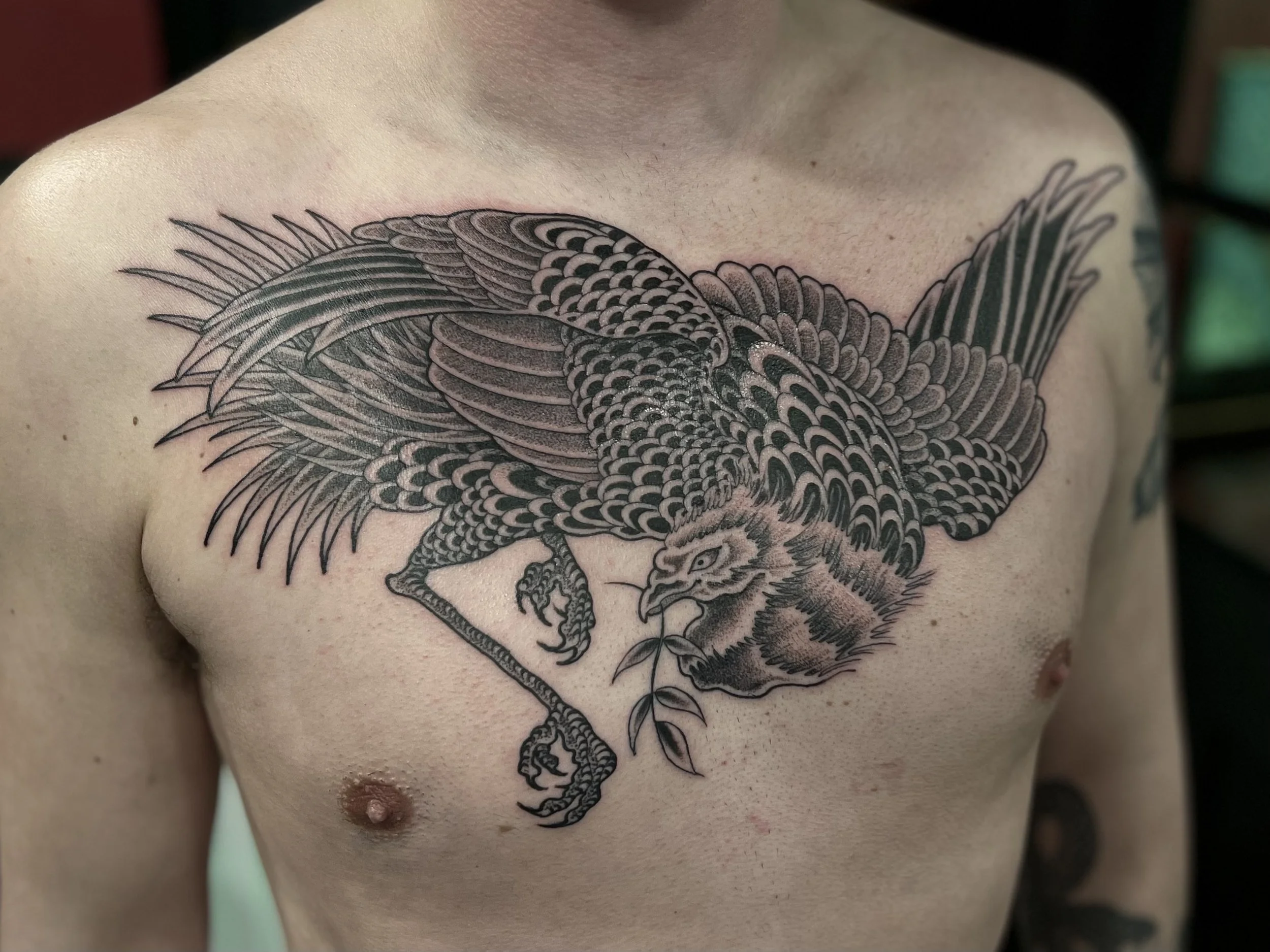 Fine line Japanese style Liverbird tattoo on the chest done at Frith Street Tattoos, Soho, central London.