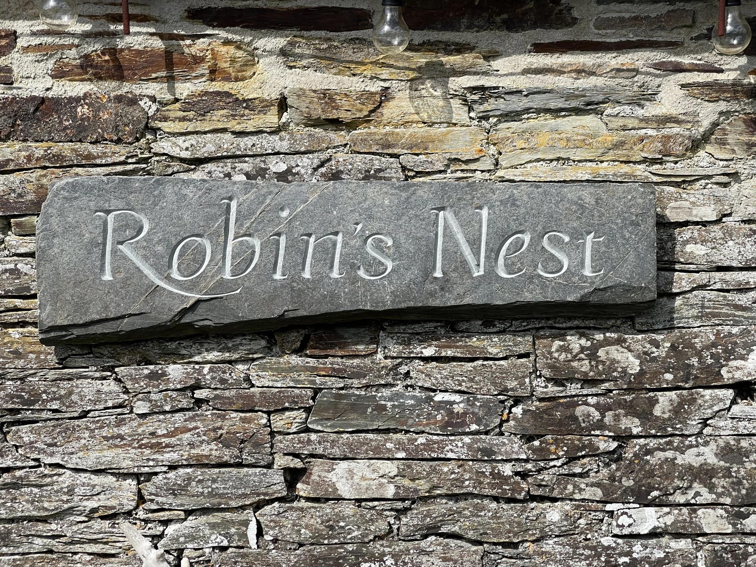 Stone carved house-sign in riven Delabole slate.