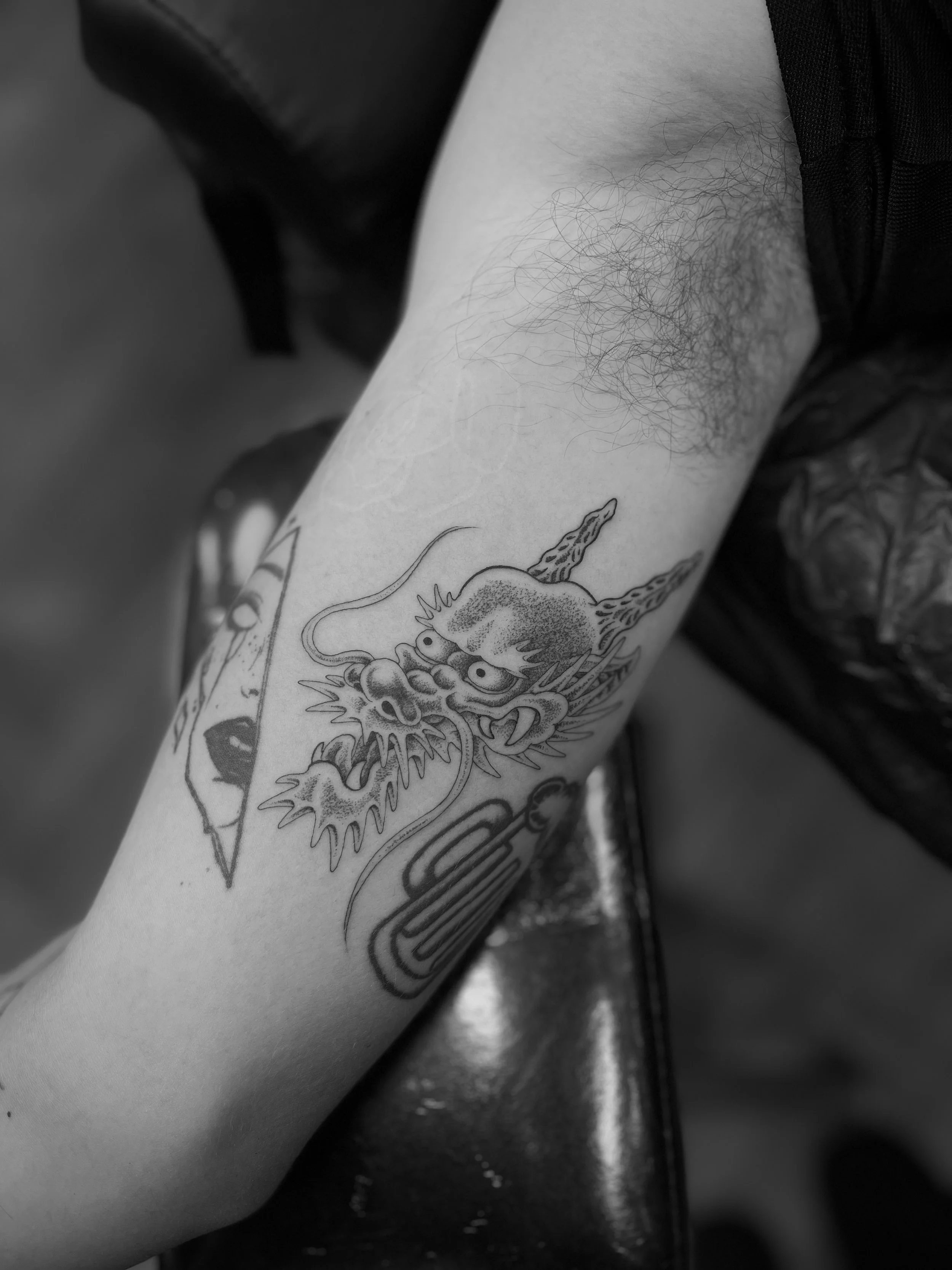 Single needle dragon head tattoo on the bicep, done at Frith Street Tattoos, Soho, central London.