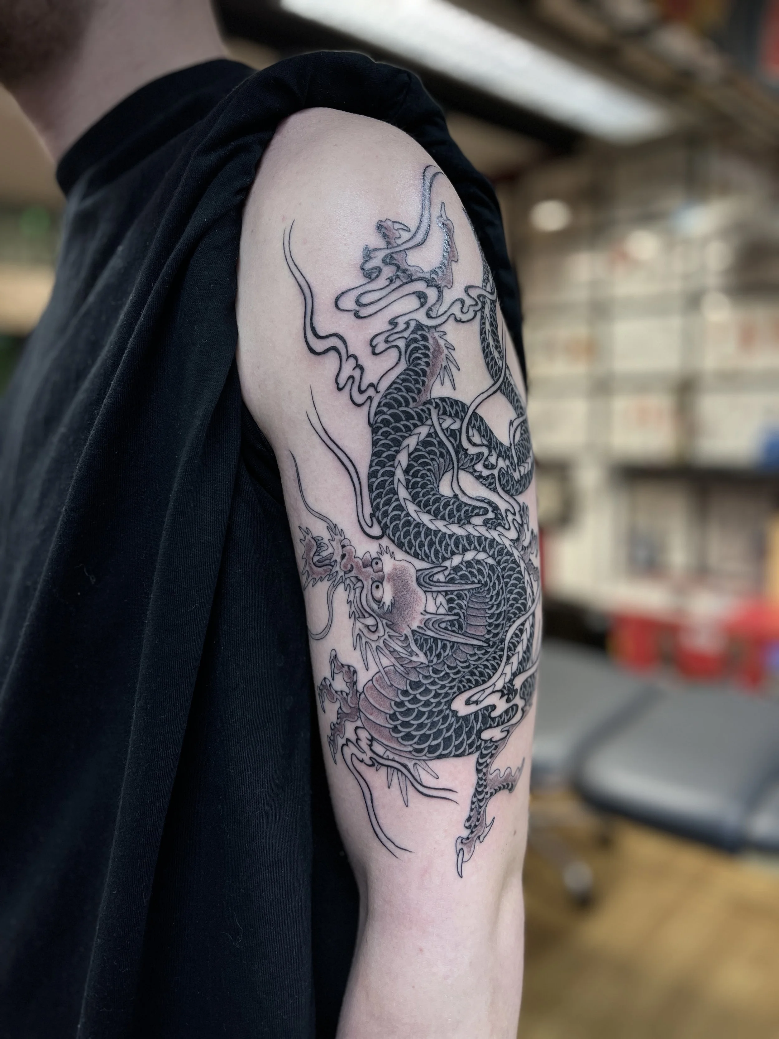 Single needle black and grey dragon tattoo. Made in London