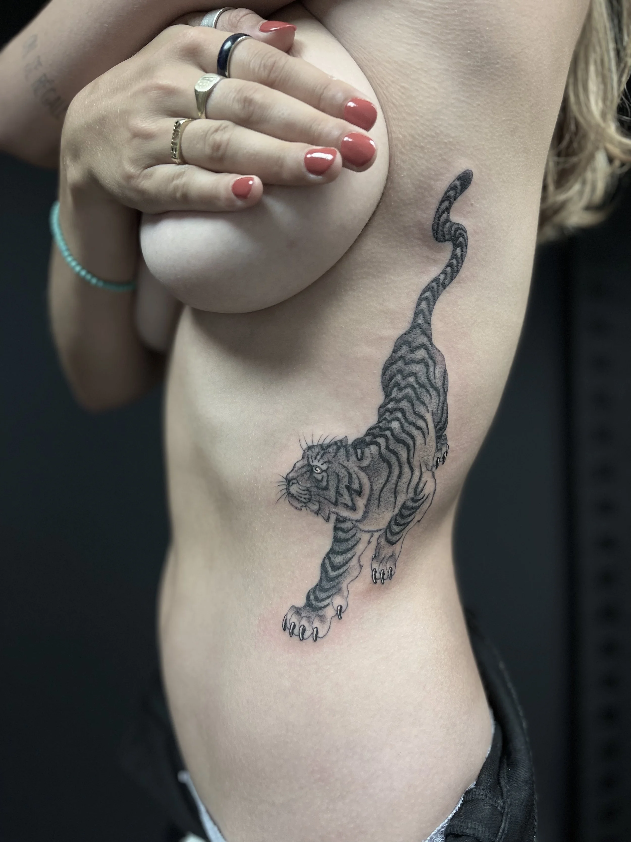 Single needle, black and grey tiger tattoo on the ribs, done at Frith Street Tattoos, Soho, central London.
