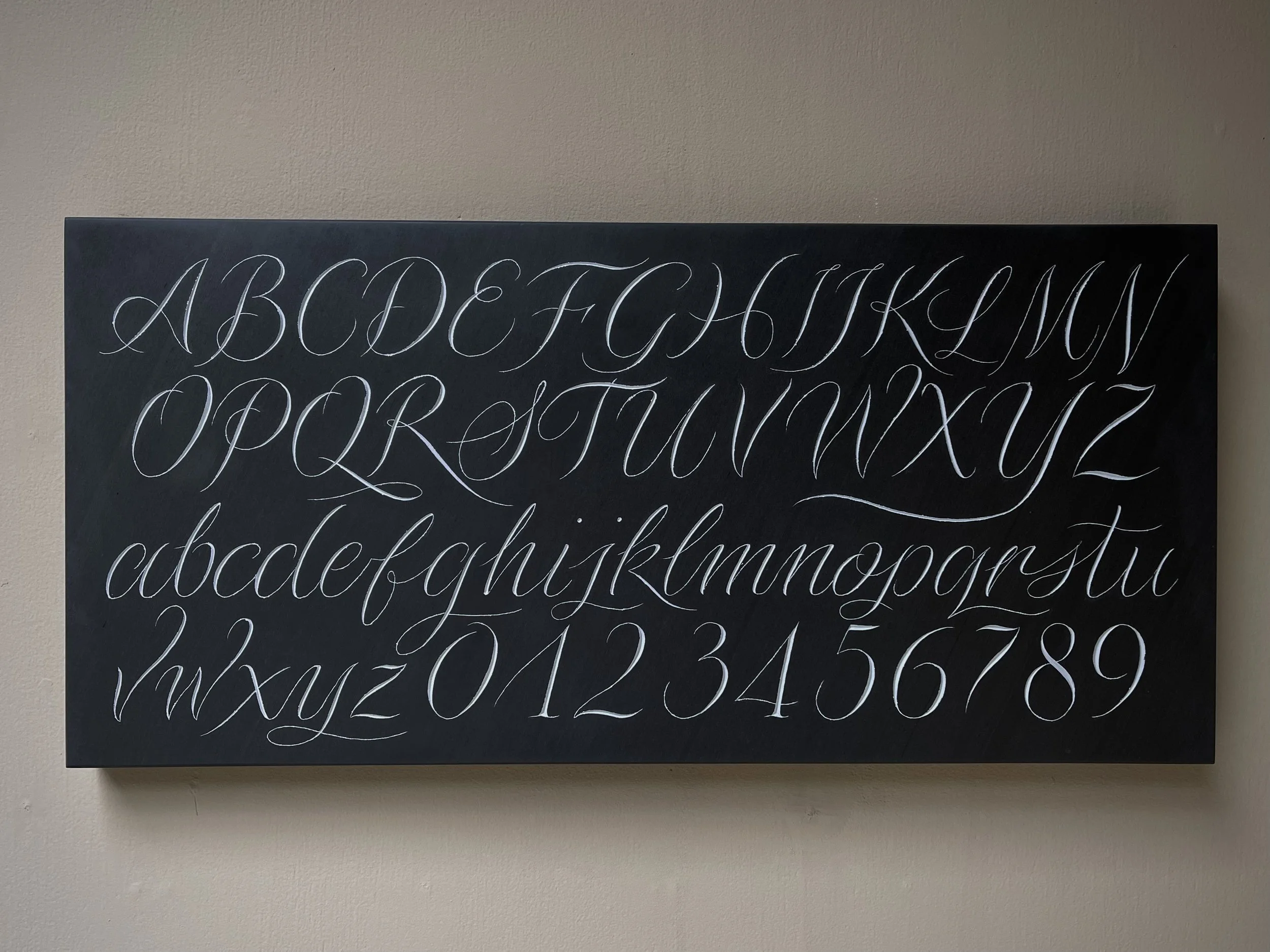 Alphabet and numbers in slate, carved by hand and painted.