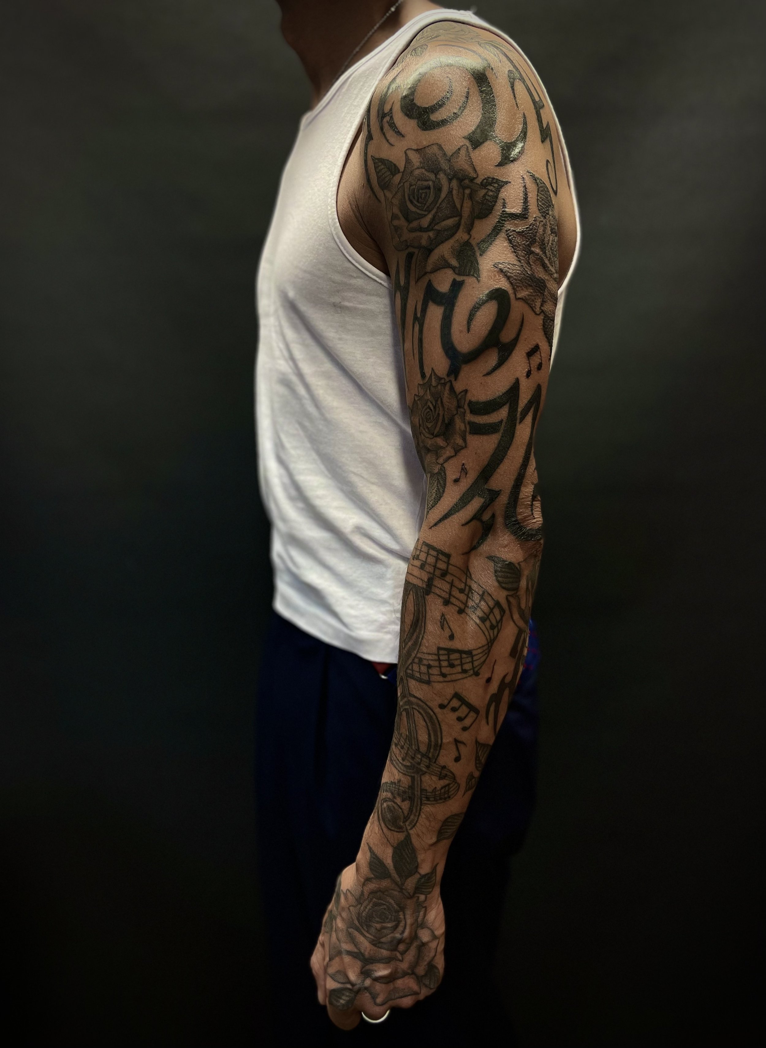 Tribal, rose and music sleeve tattoo, done at Frith Street Tattoos, Soho, central London.