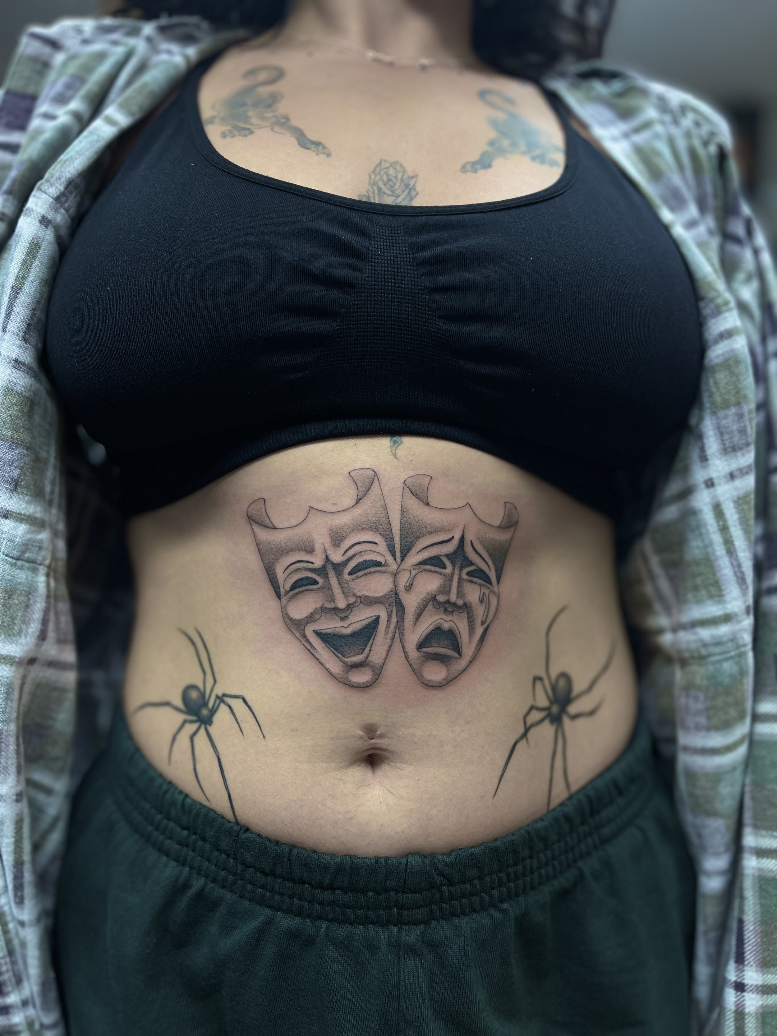 Single needle theatre mask tattoo, with healed spider tattoos, on the belly. Done at Frith Street Tattoos, Soho, central London.