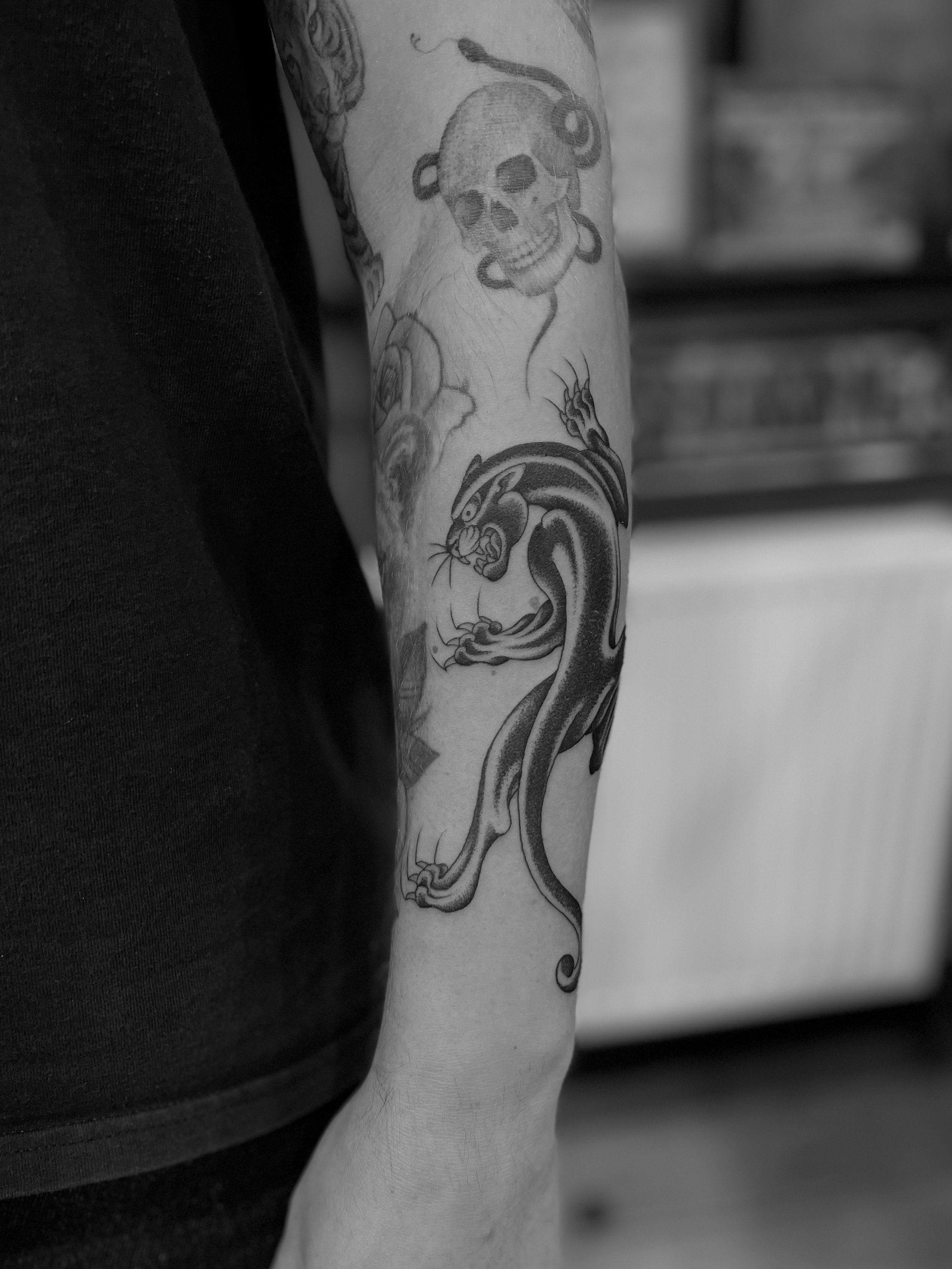 Fine line, black and grey panther tattoo on the arm, done at Frith Street Tattoos, Soho, central London.