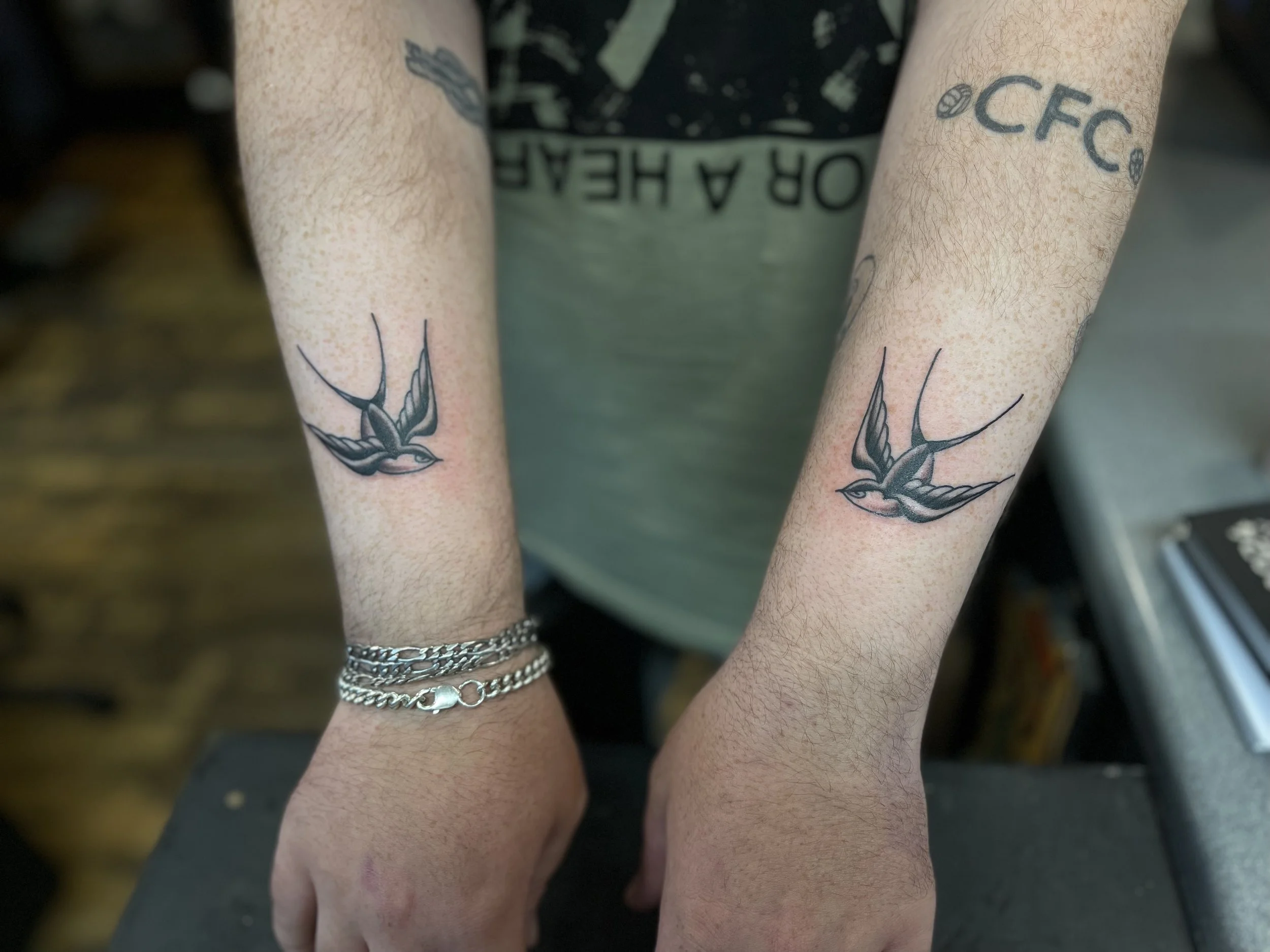 Traditional swallow tattoos on the wrist, done at Frith Street Tattoos, Soho, central London.