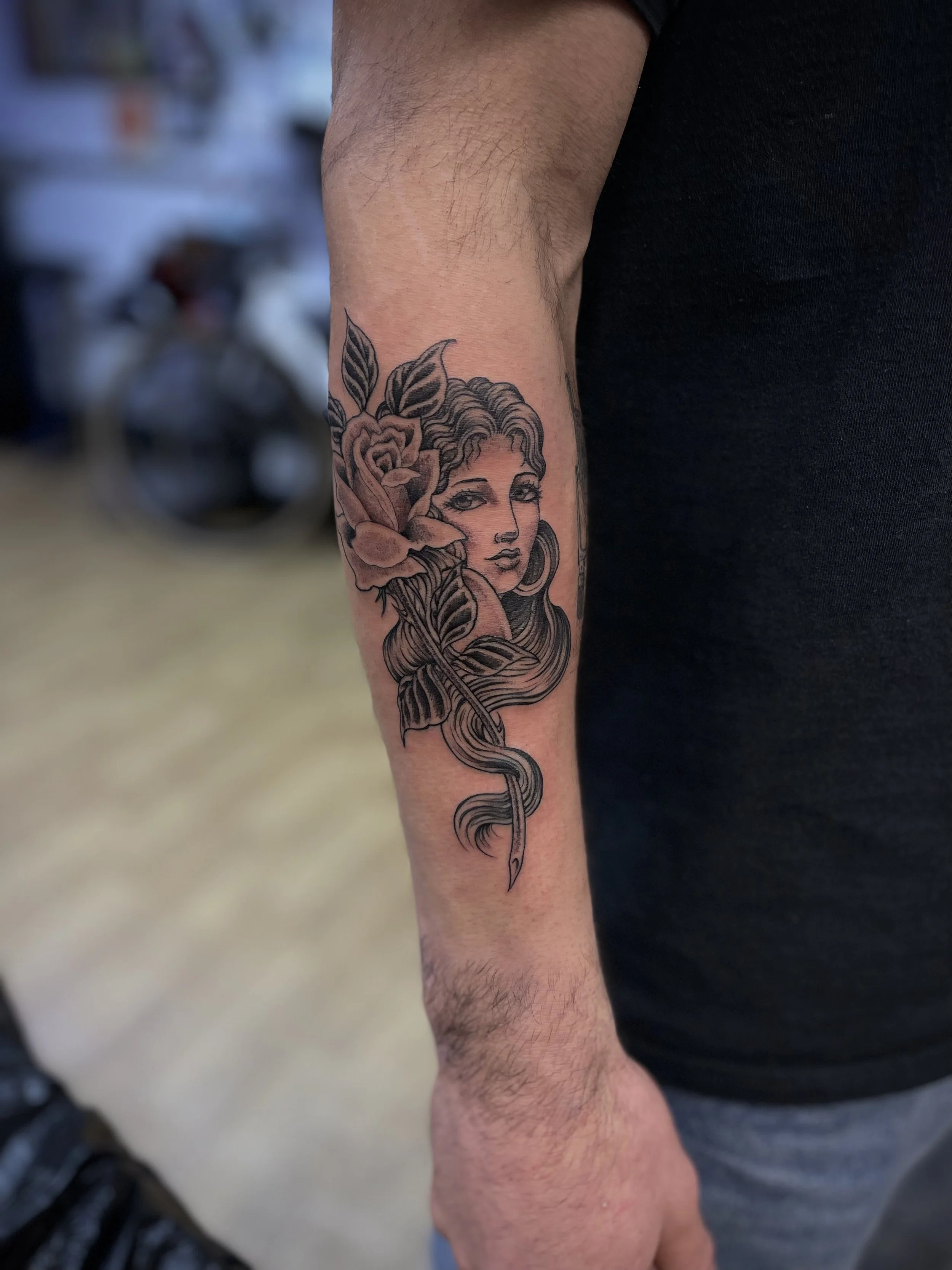 Fine line, black and grey girl and rose tattoo on the forearm. Done at Frith Street Tattoos, Soho, central London.