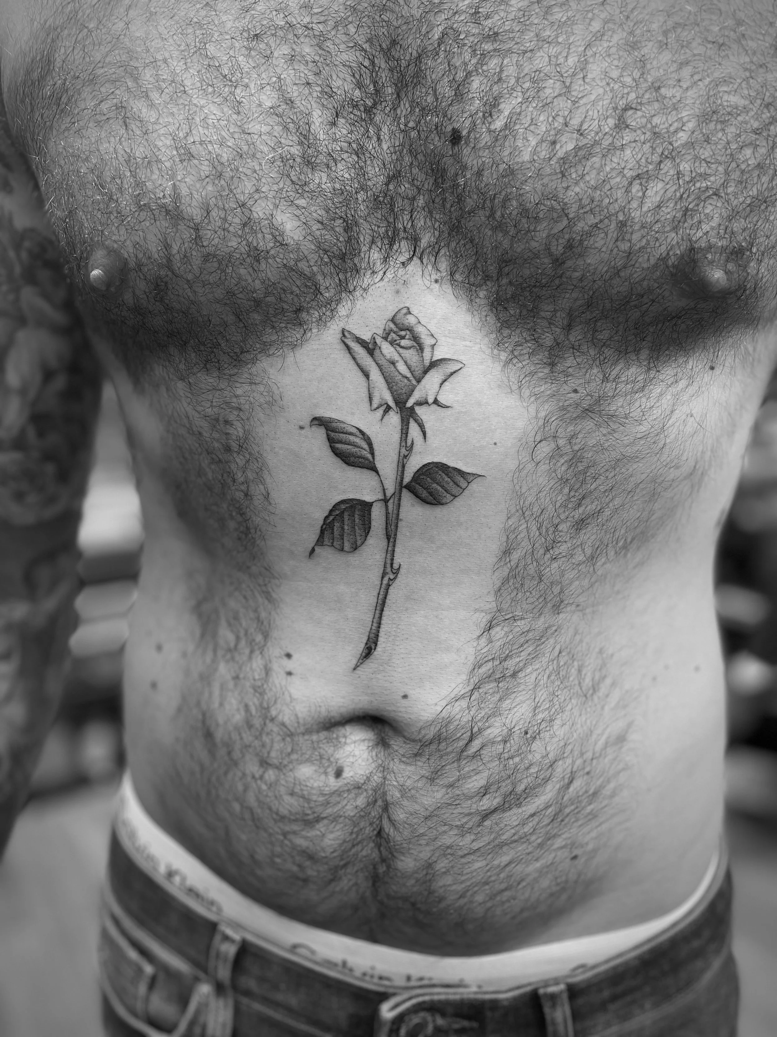 FIne line, single needle rose tattoo on the stomach, done at Frith Street Tattoos, Soho, central London.
