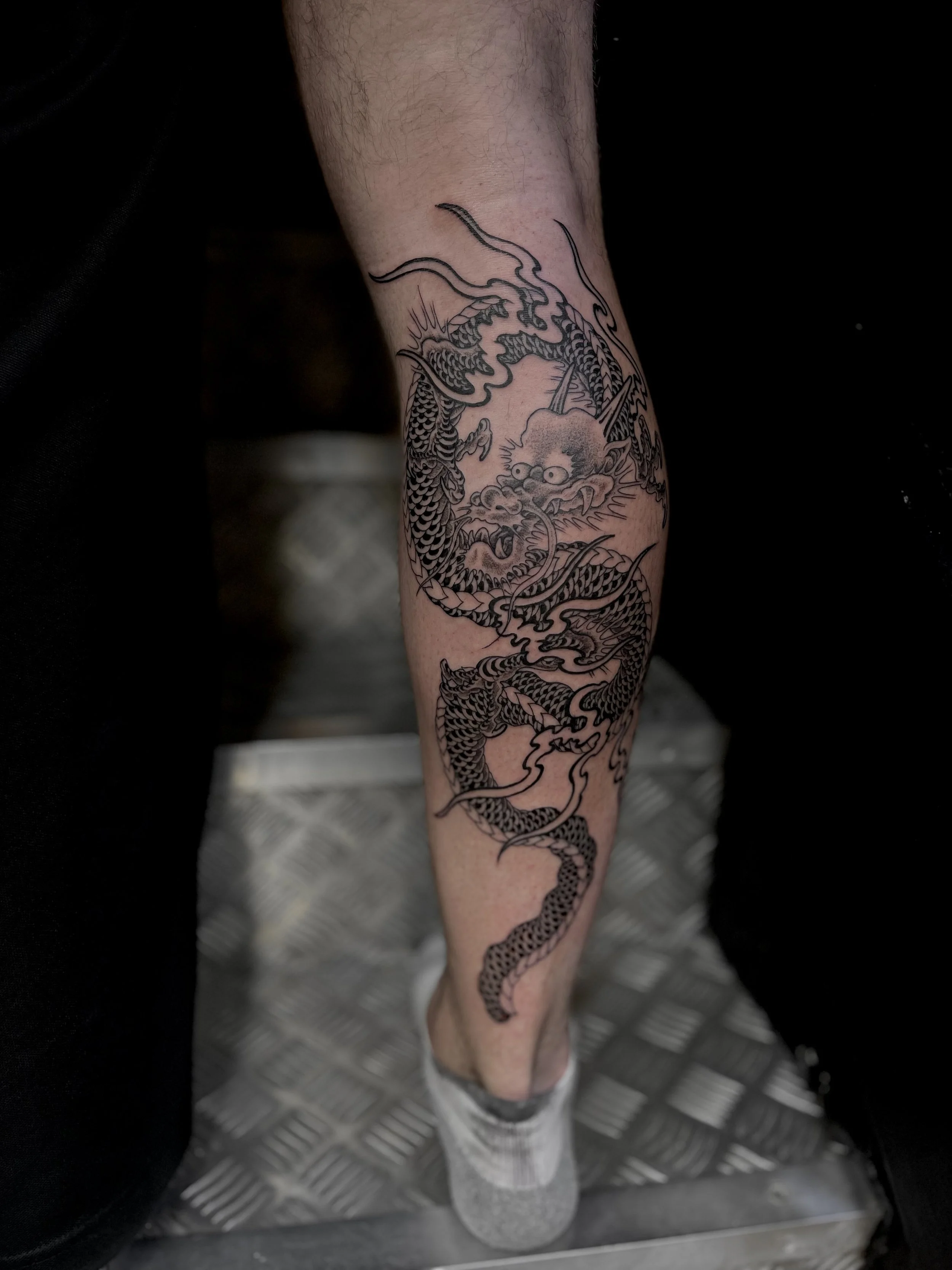 Fine line, B&G Japanese dragon on the calf done at Frith Street Tattoos, Soho, central London.