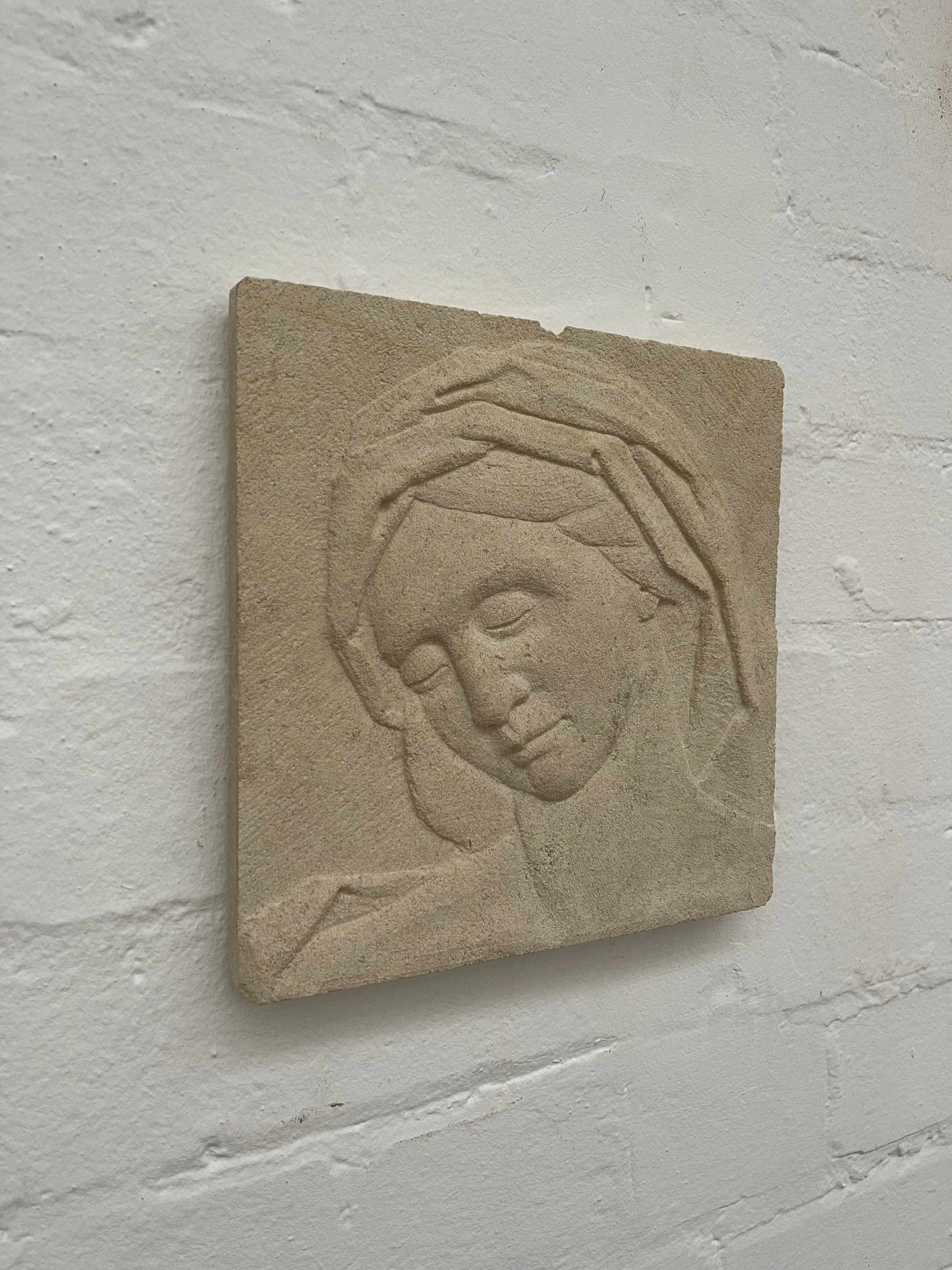 Stone carving of a mother's head in Caen limestone.