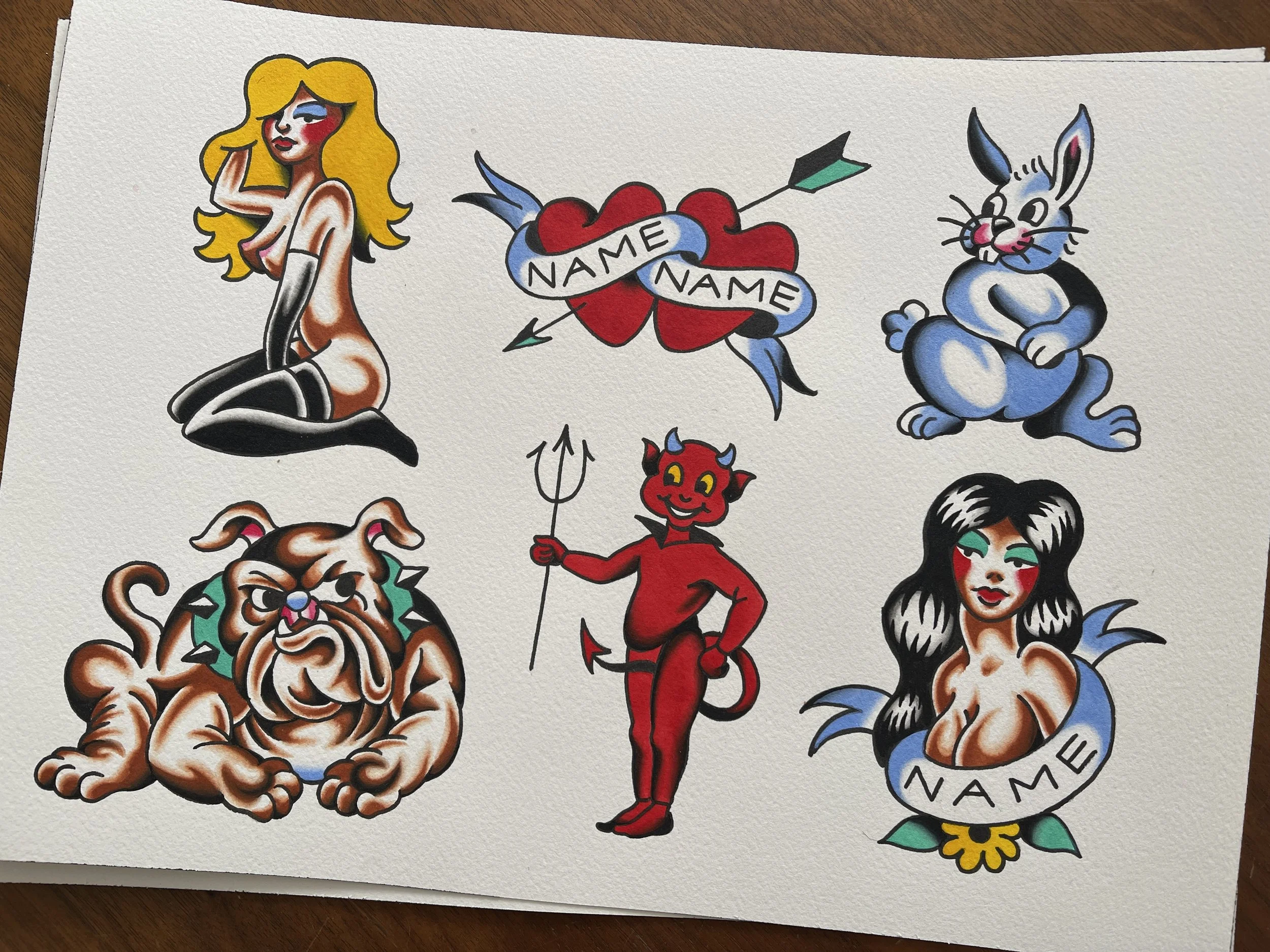 Traditional tattoo flash sheet of devil, girls, rabbit, hearts and bulldog, designs available to be tattooed at Frith Street Tattoos, Soho, London