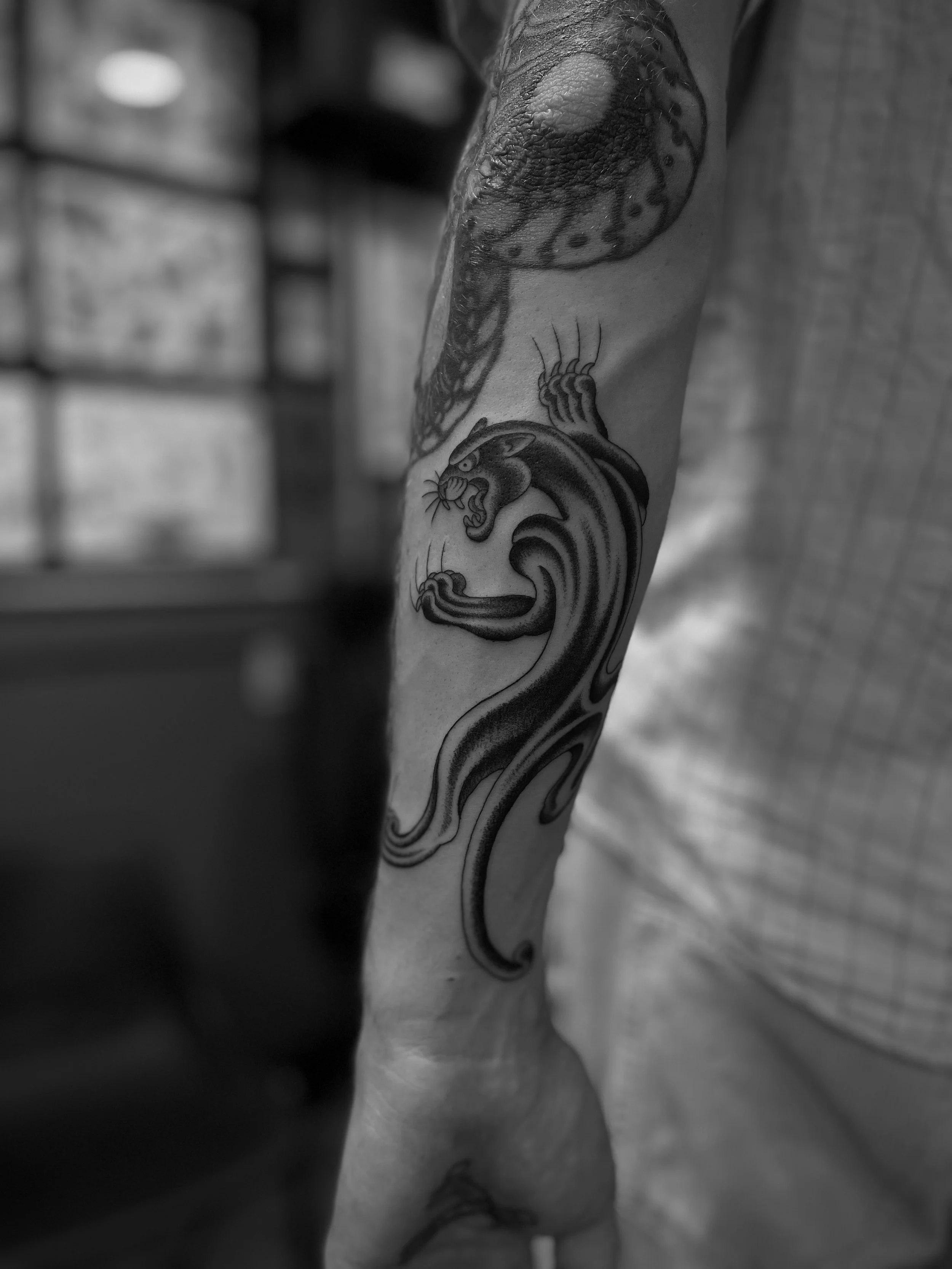 Fine line panther tattoo on the forearm, done at Frith Street Tattoos, Soho, central London.