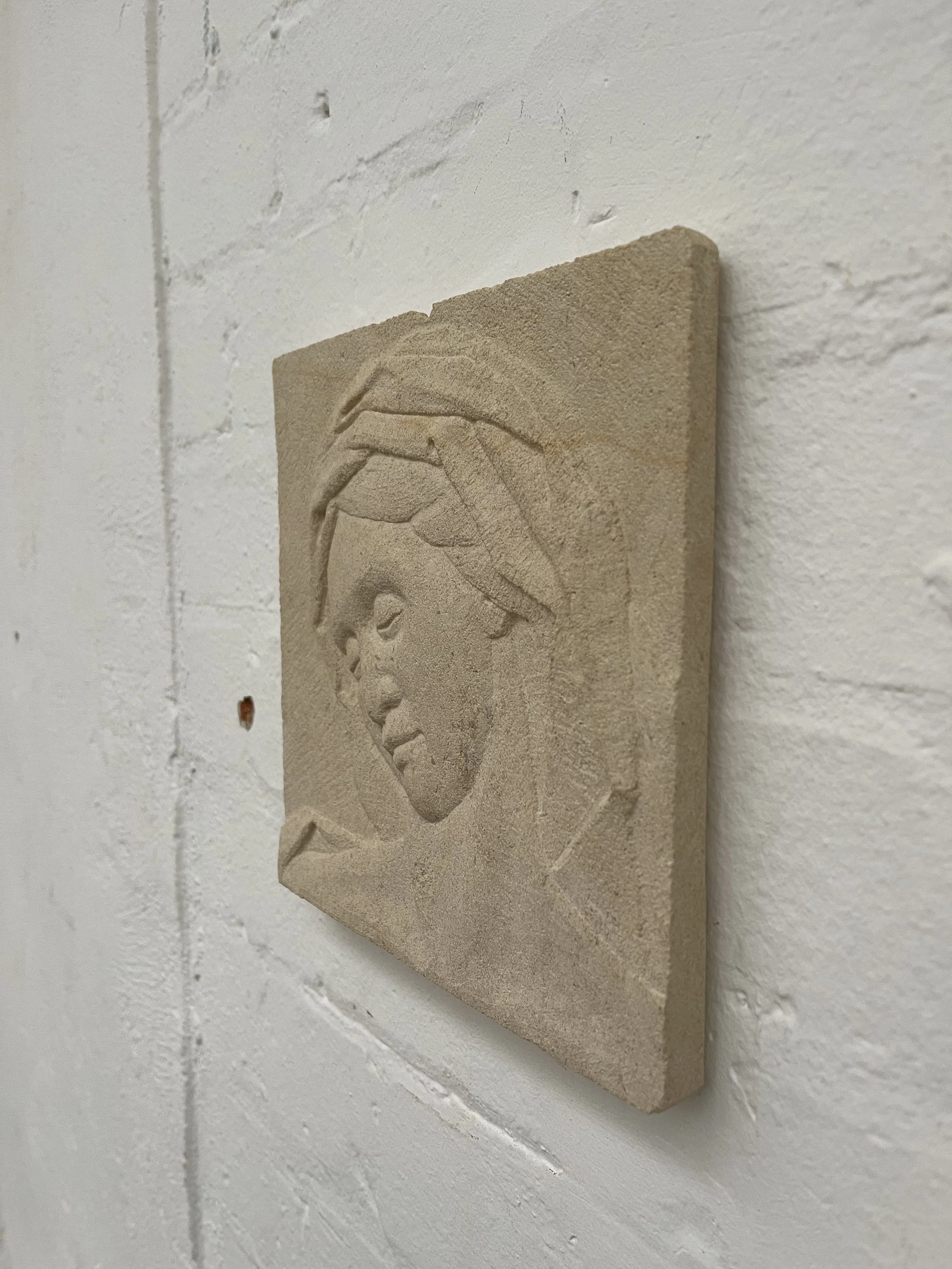 Stone carving of a mother's head in Caen limestone.