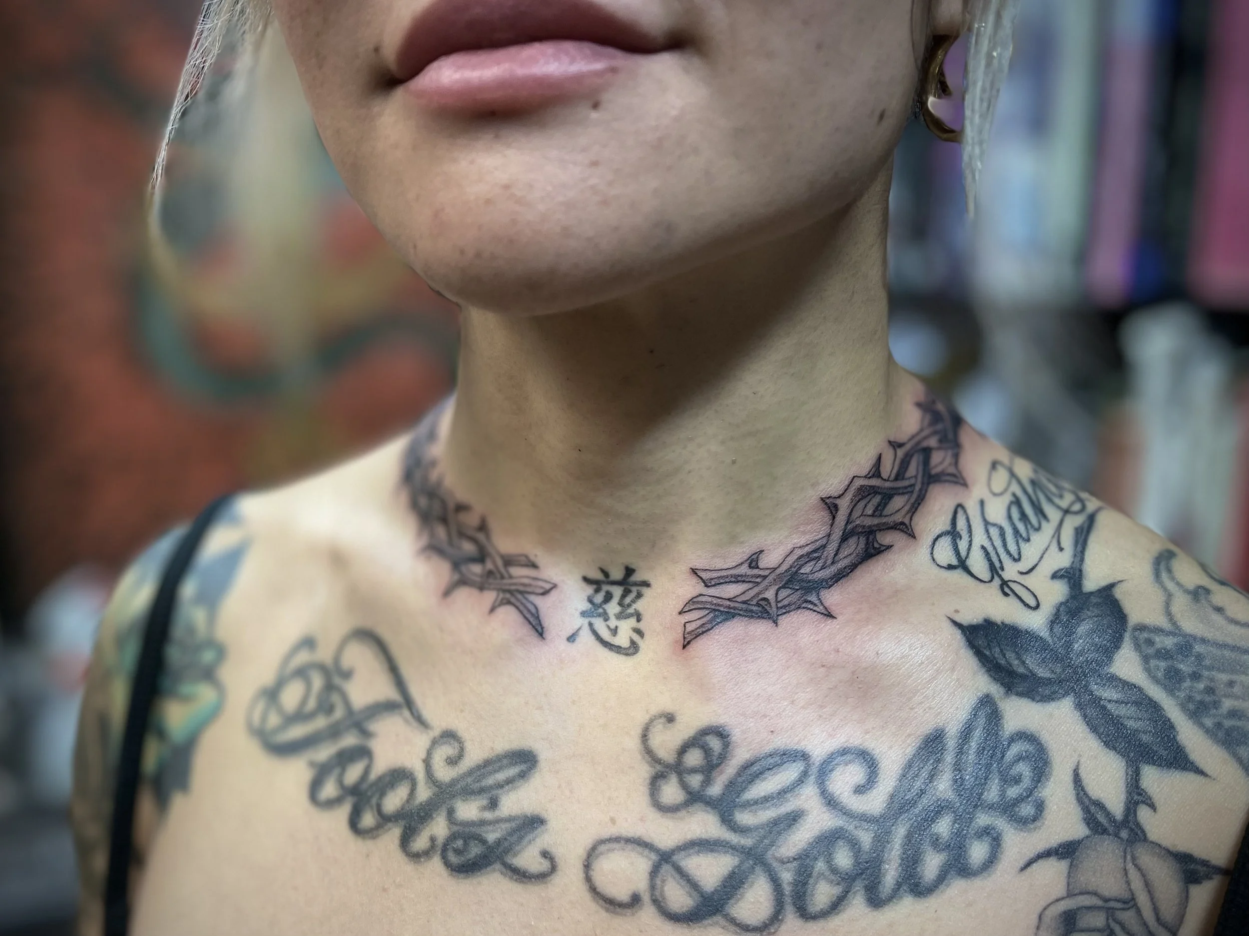 Fine line black and grey thorns tattoo, round the collar, done at Frith Street Tattoos, Soho, central London.