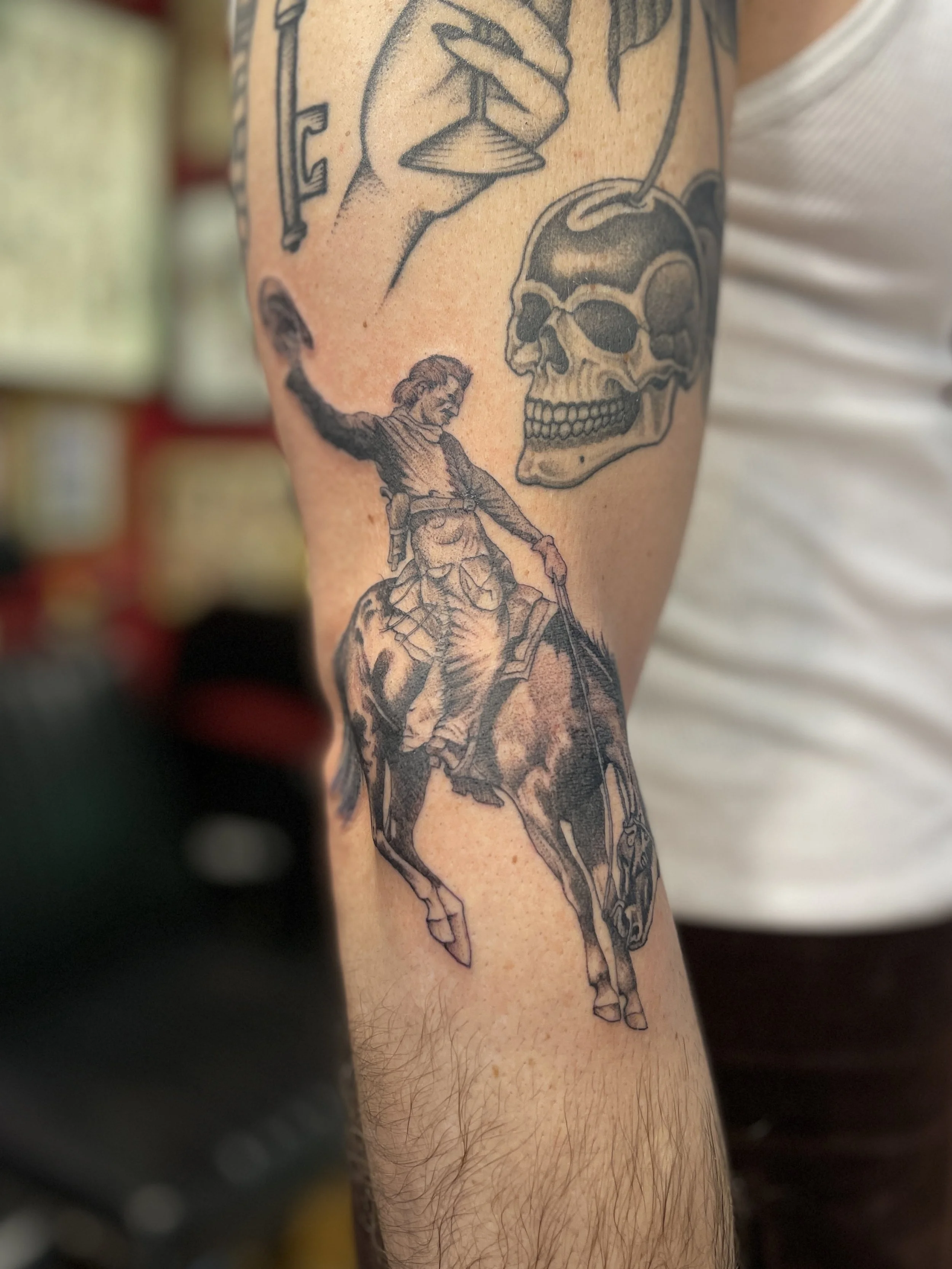 Single needle tattoo of a cowboy on bucking horse, made in Soho, central London.