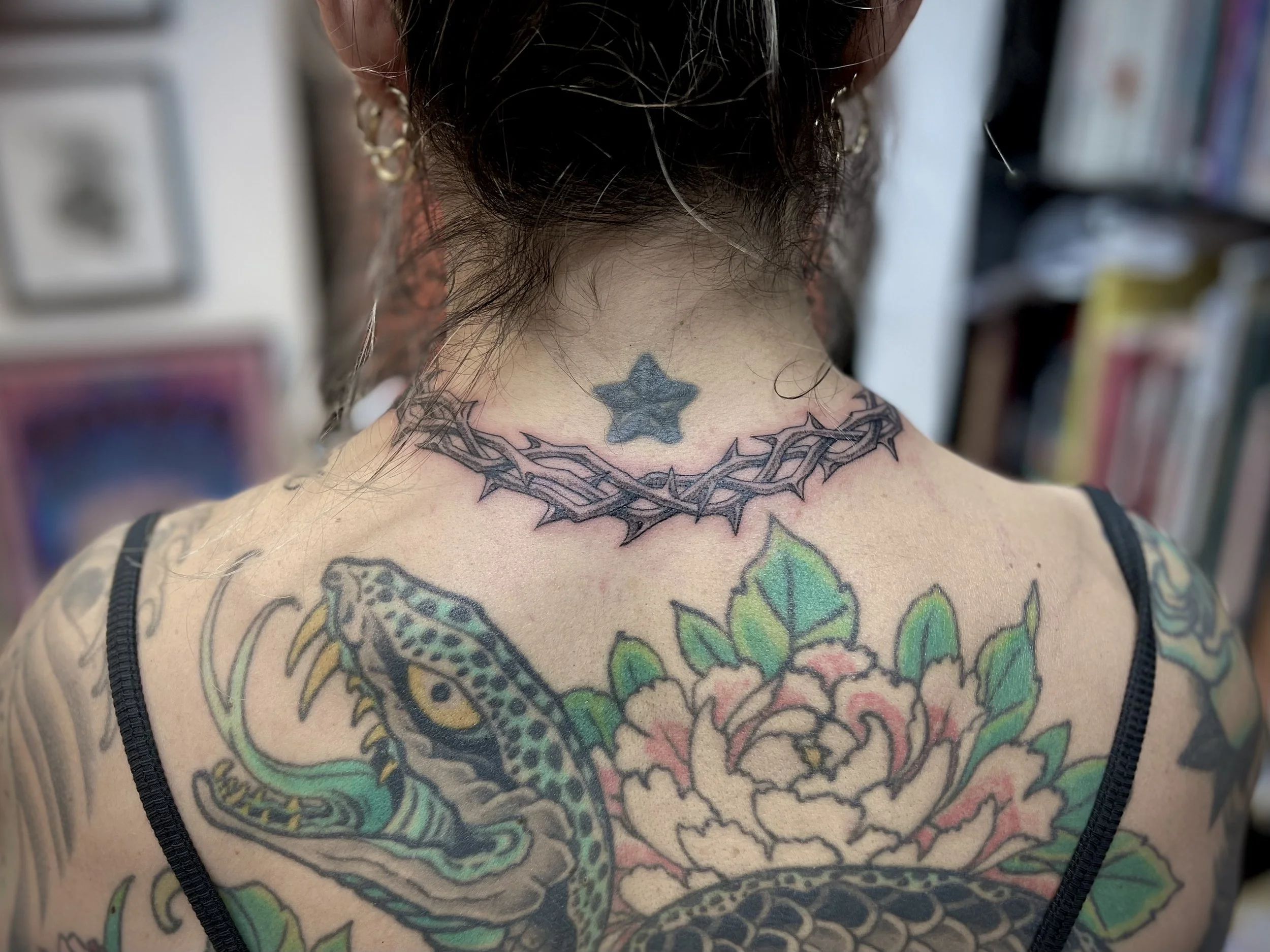 Fine line black and grey thorns tattoo, round the collar, done at Frith Street Tattoos, Soho, central London.