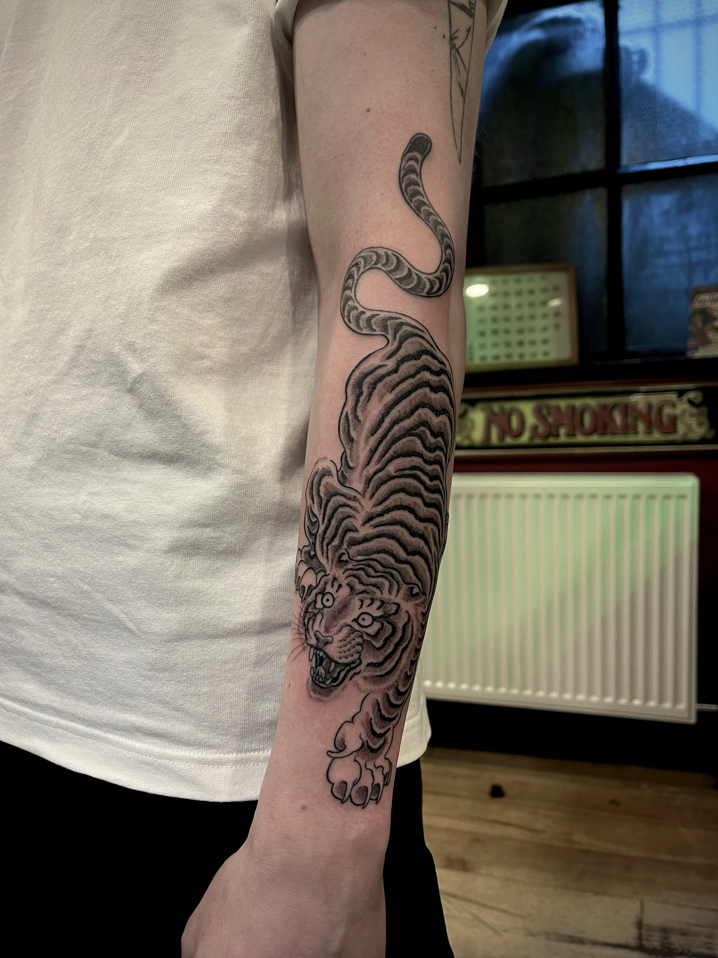 Fine line tiger tattoo on the forearm, done at Frith Street Tattoos, Soho, central London.