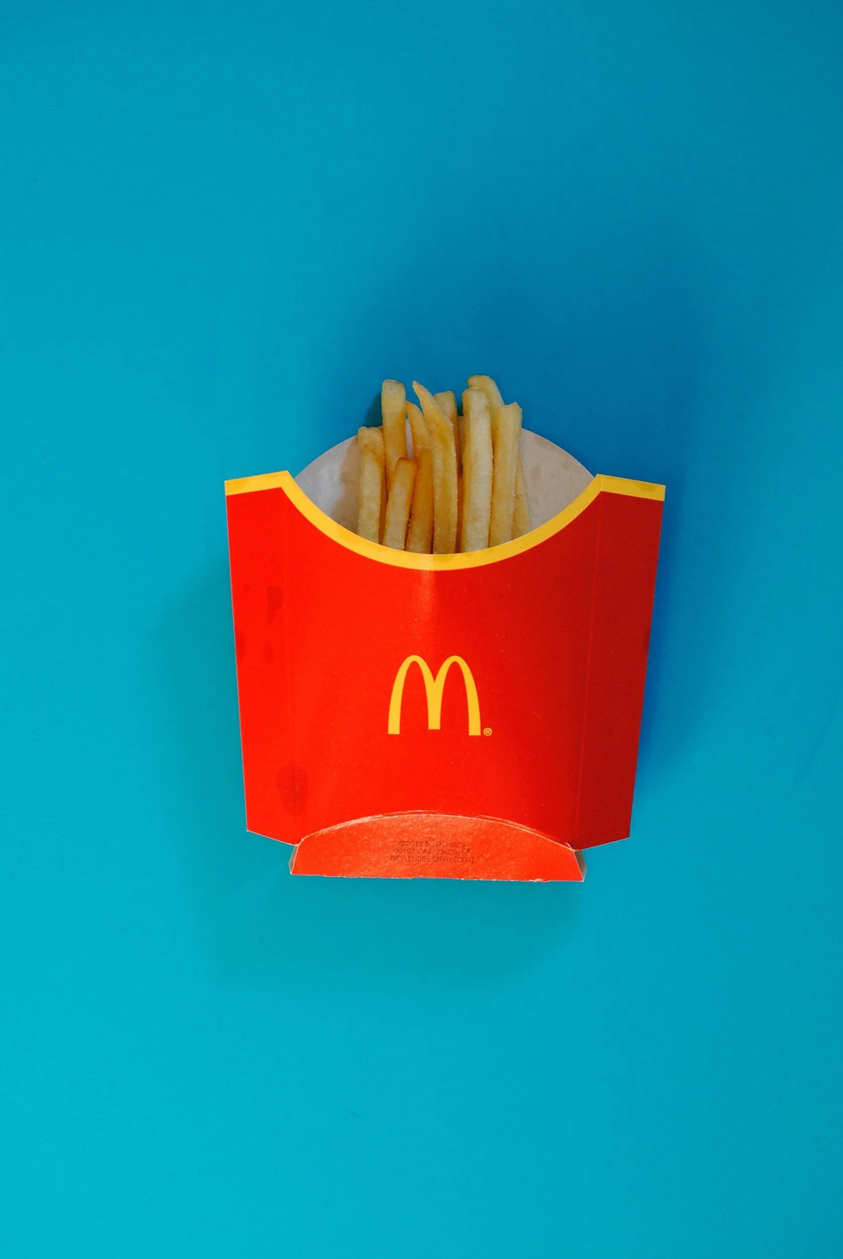 An image showing a packet of McDonald's Fries on a bright blue background in support of a case study about the building of a Behaviour Accelerator programme for McDonald's App Users in Hong Kong