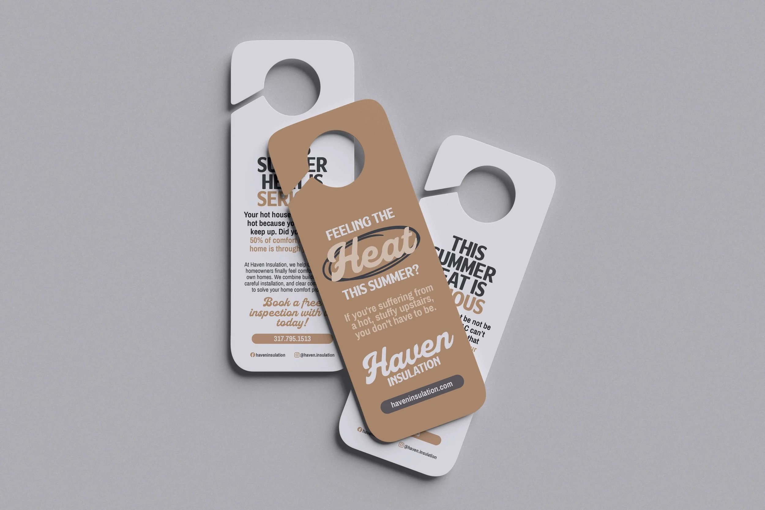 Door hangers from Haven Insulation arranged on a gray surface, with one card overlapping a pamphlet and a brown promotional insert.