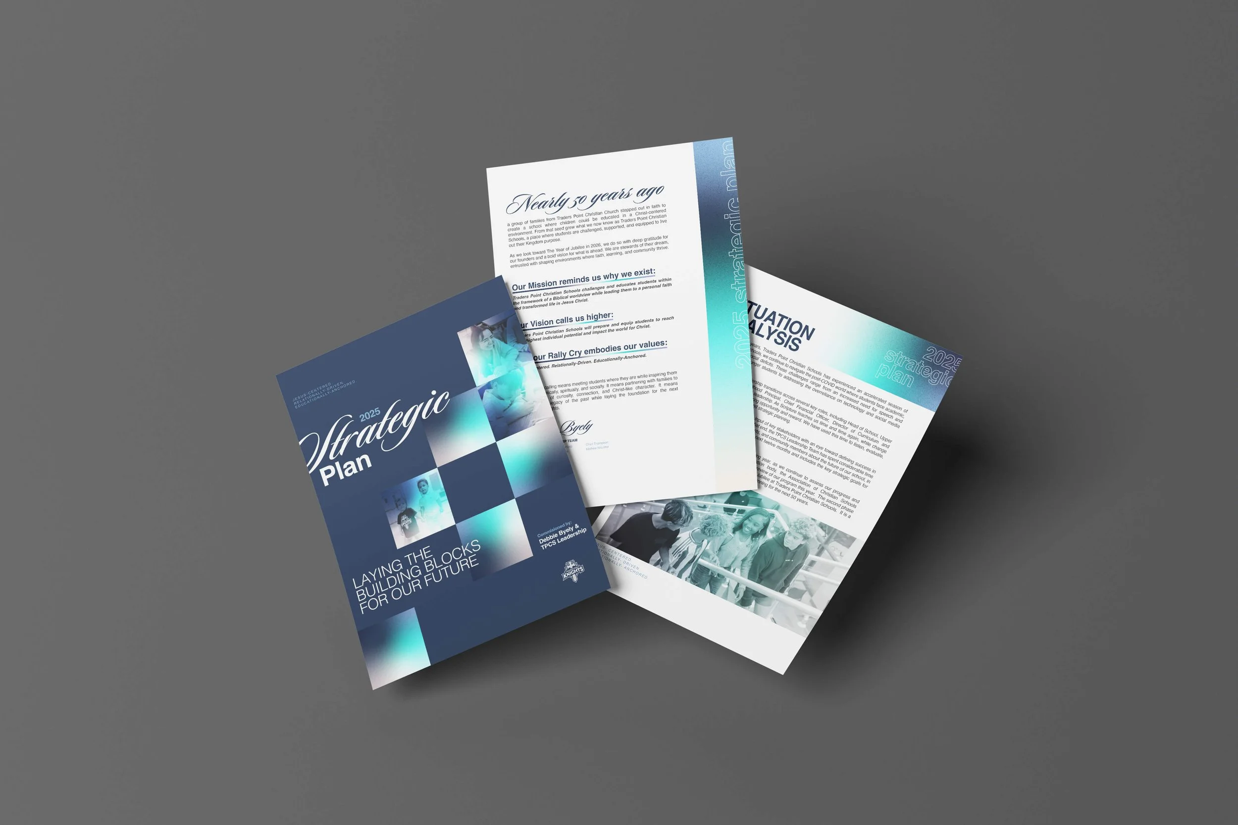 Three printed documents or pamphlets titled "Strategic Plan 2025" and related to education or community development, laid on a dark gray surface.