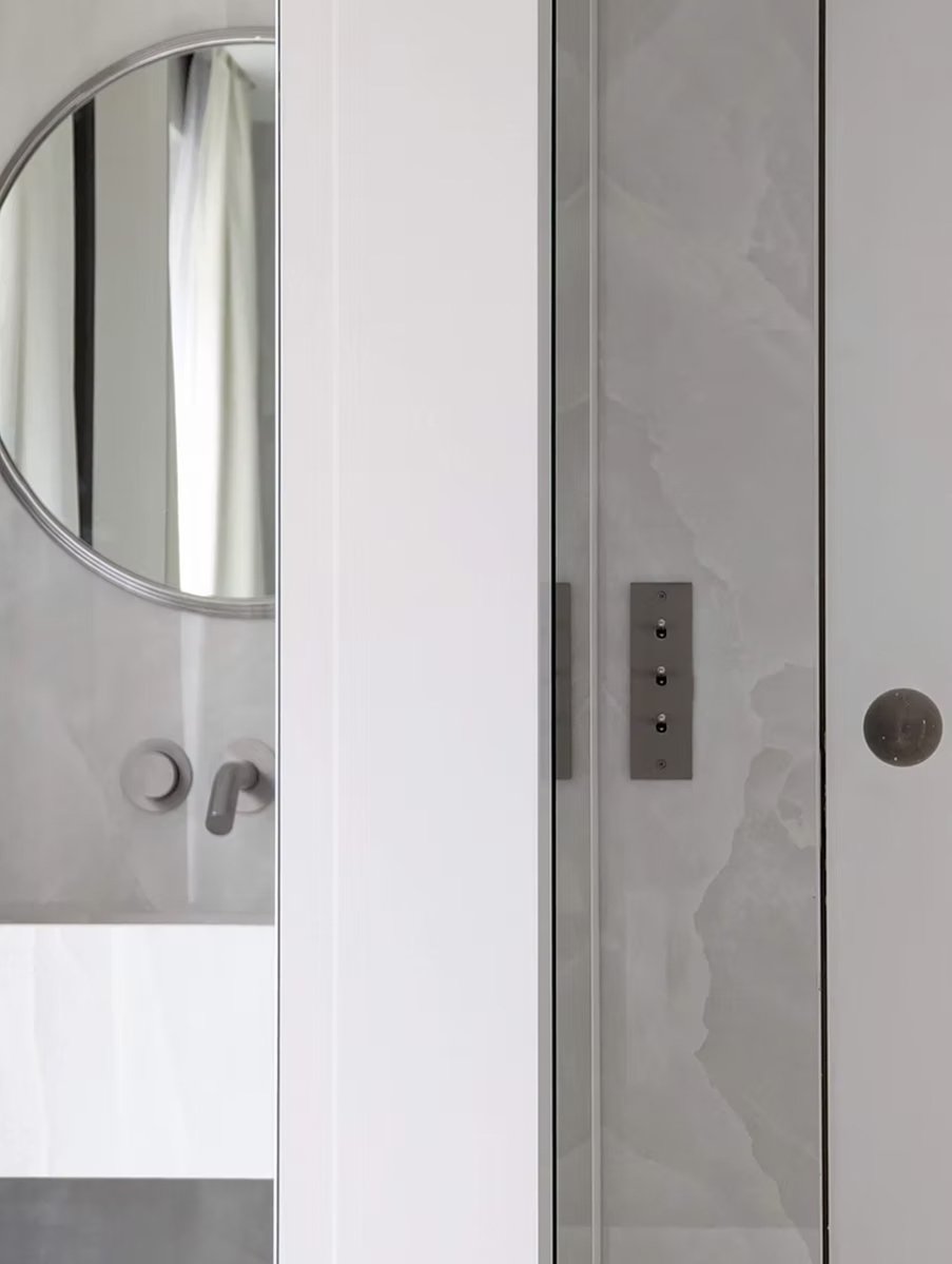 Ascenseur avec miroir et porte en marbre, mur blanc à gauche