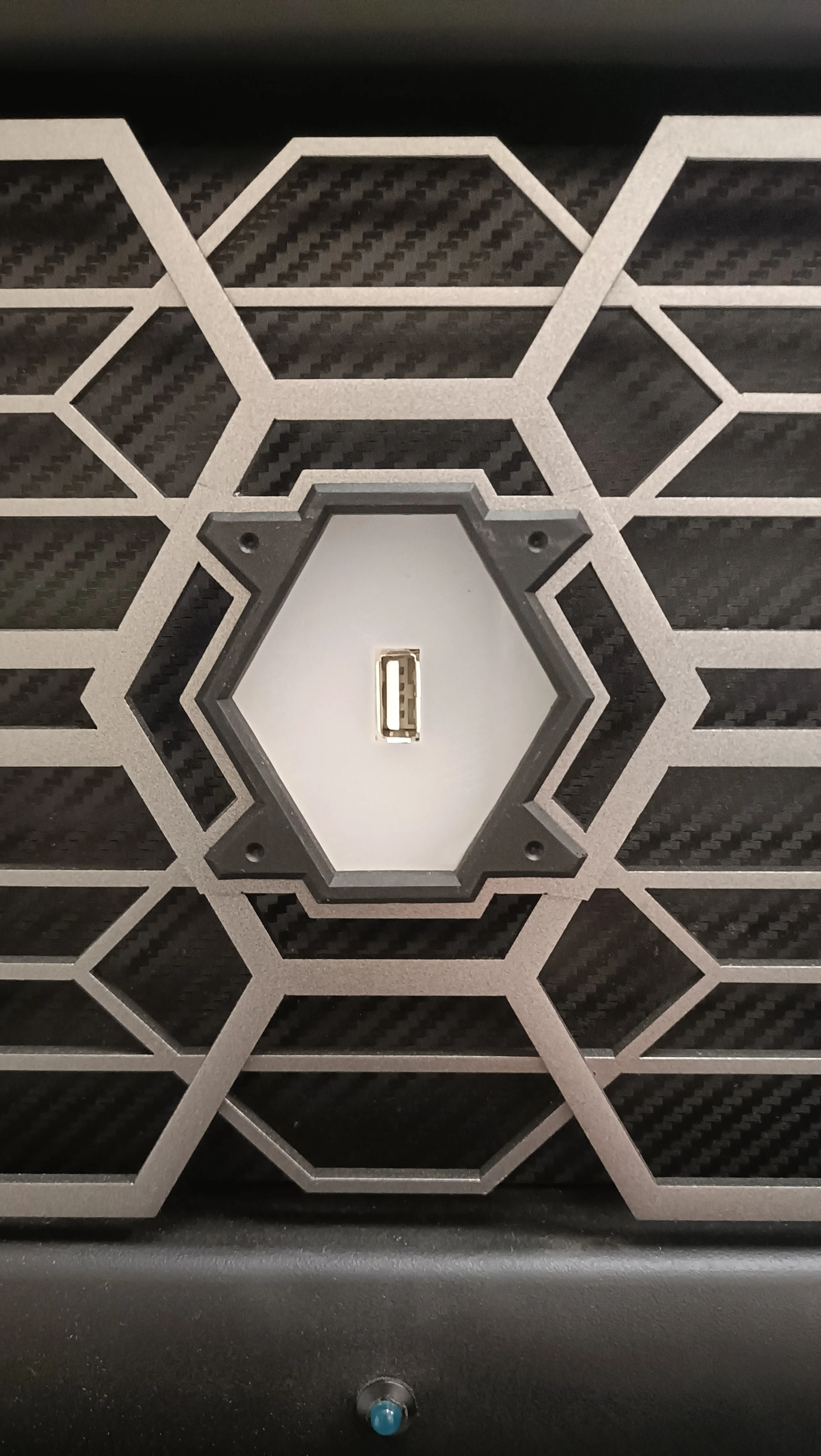 A close-up of a hexagonal pattern on a surface with a USB port in the center.
