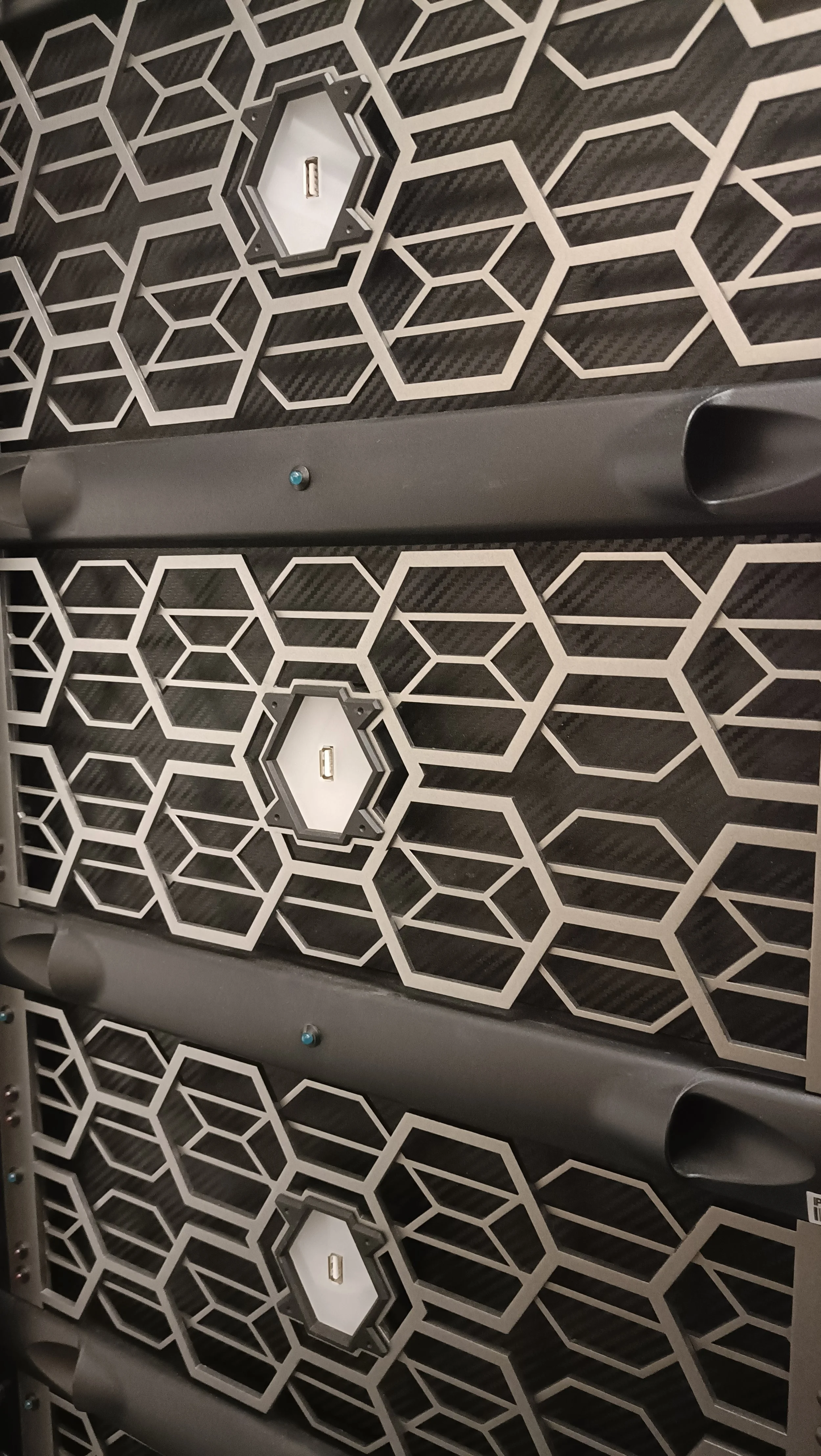 Close-up of a wall panel with a hexagonal pattern and built-in USB charging ports.