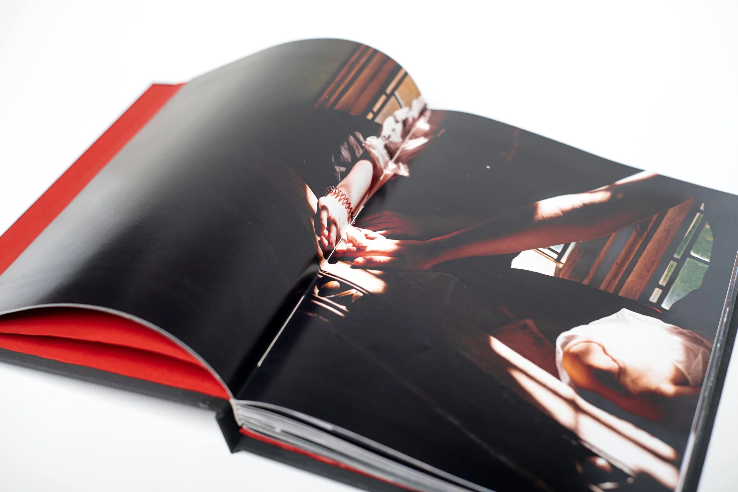 Open magazine showing a photo of a person's arm and hand with a bracelet, sitting by a window with sunlight.