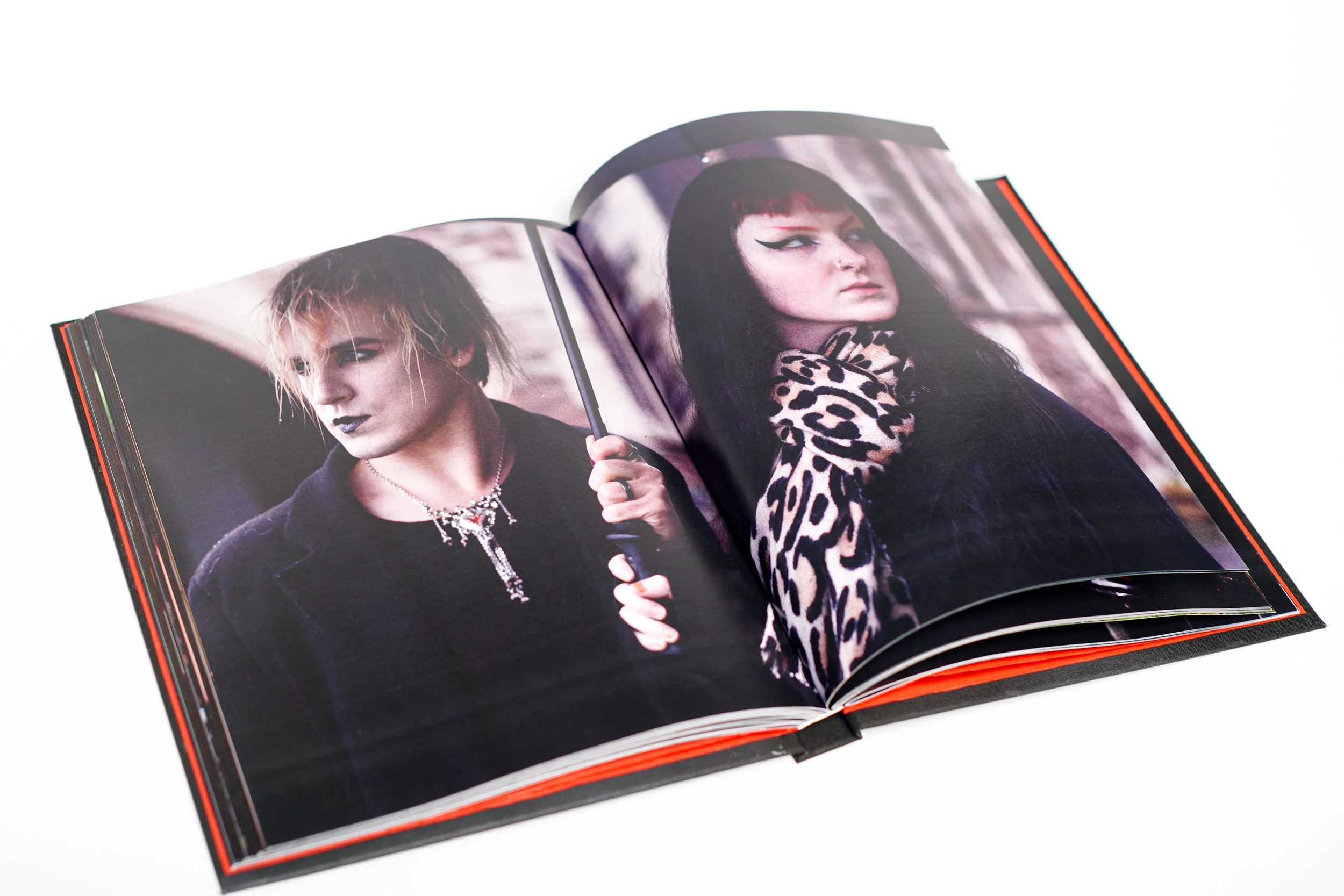 Open magazine displaying photos of two women with bold makeup and alternative fashion styles.