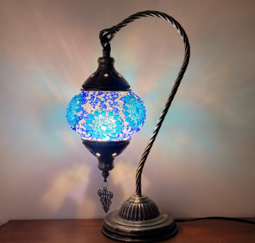 Decorative table lamp with a mosaic blue glass, metal arm, and ornate base