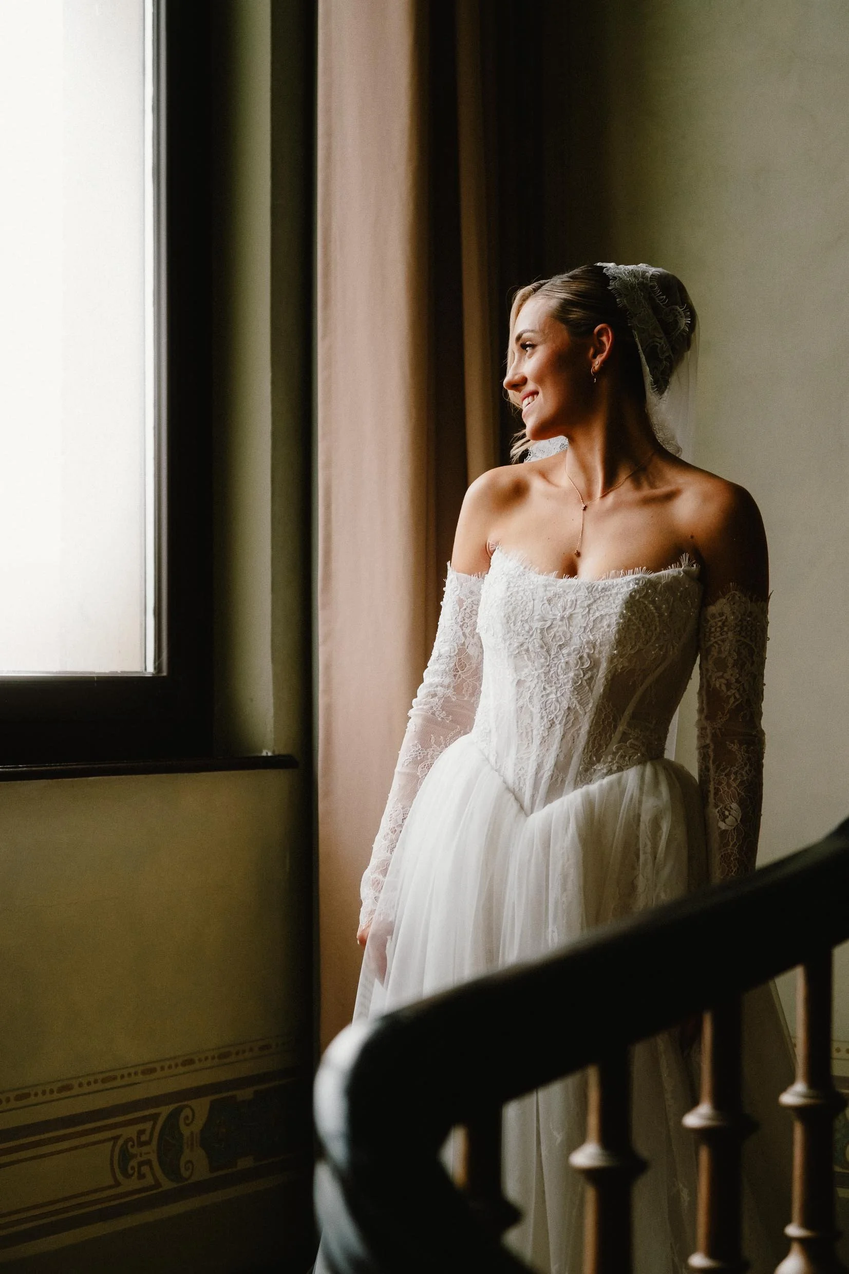 Portrait der Braut vor Fensterlicht im Treppenhaus