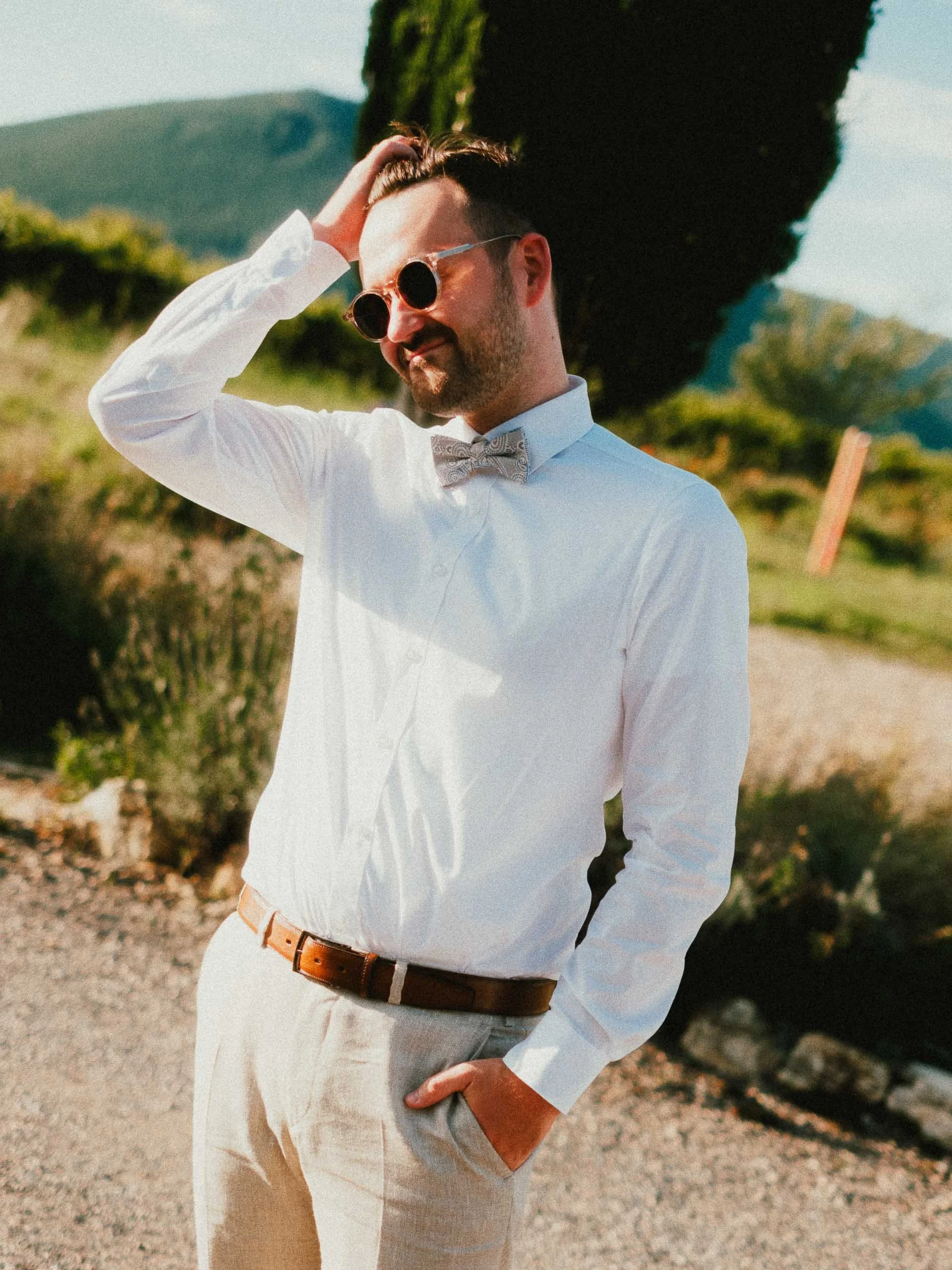 Hochzeitsgast mit Sonnenbrille und weißem Hemd in entspannter Pose