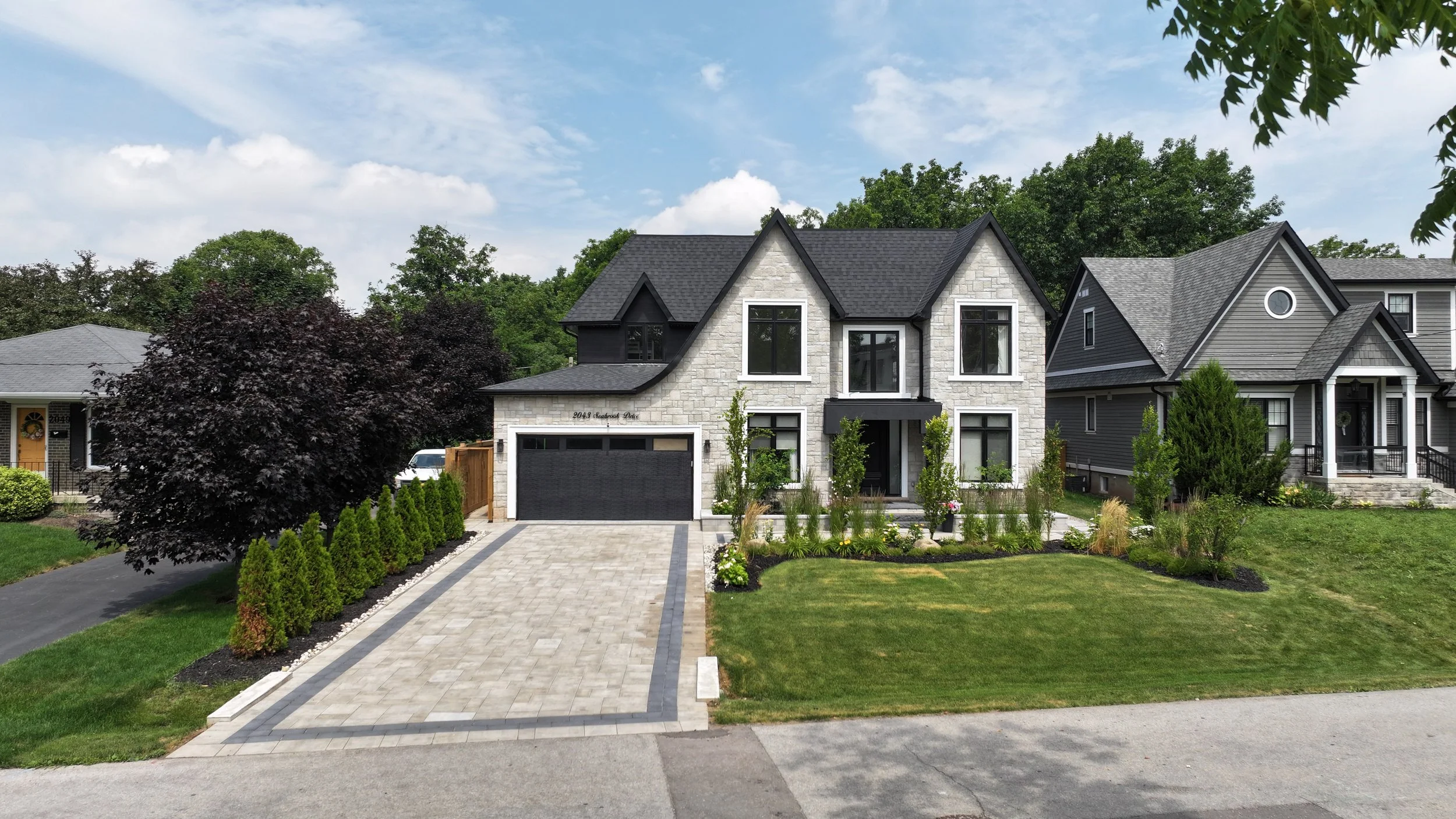 Lush green garden with various plants, bushes, and trees, and a well-maintained grassy lawn.