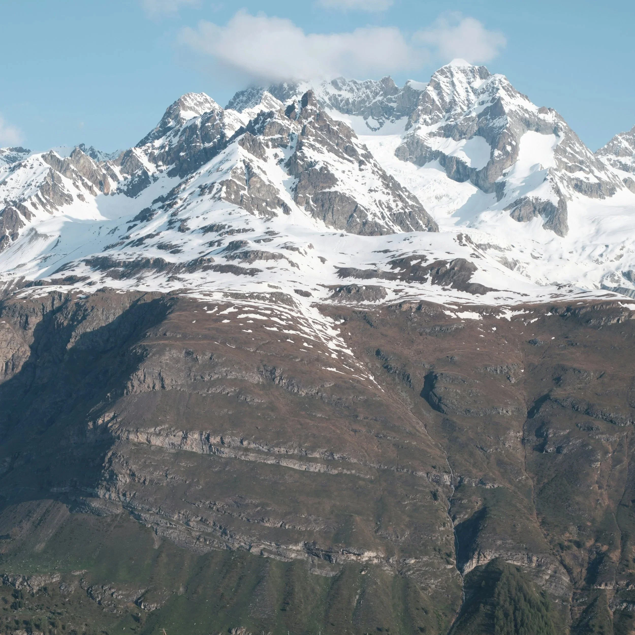 Montagnes enneigées avec sommets pointus sous un ciel bleu clair.