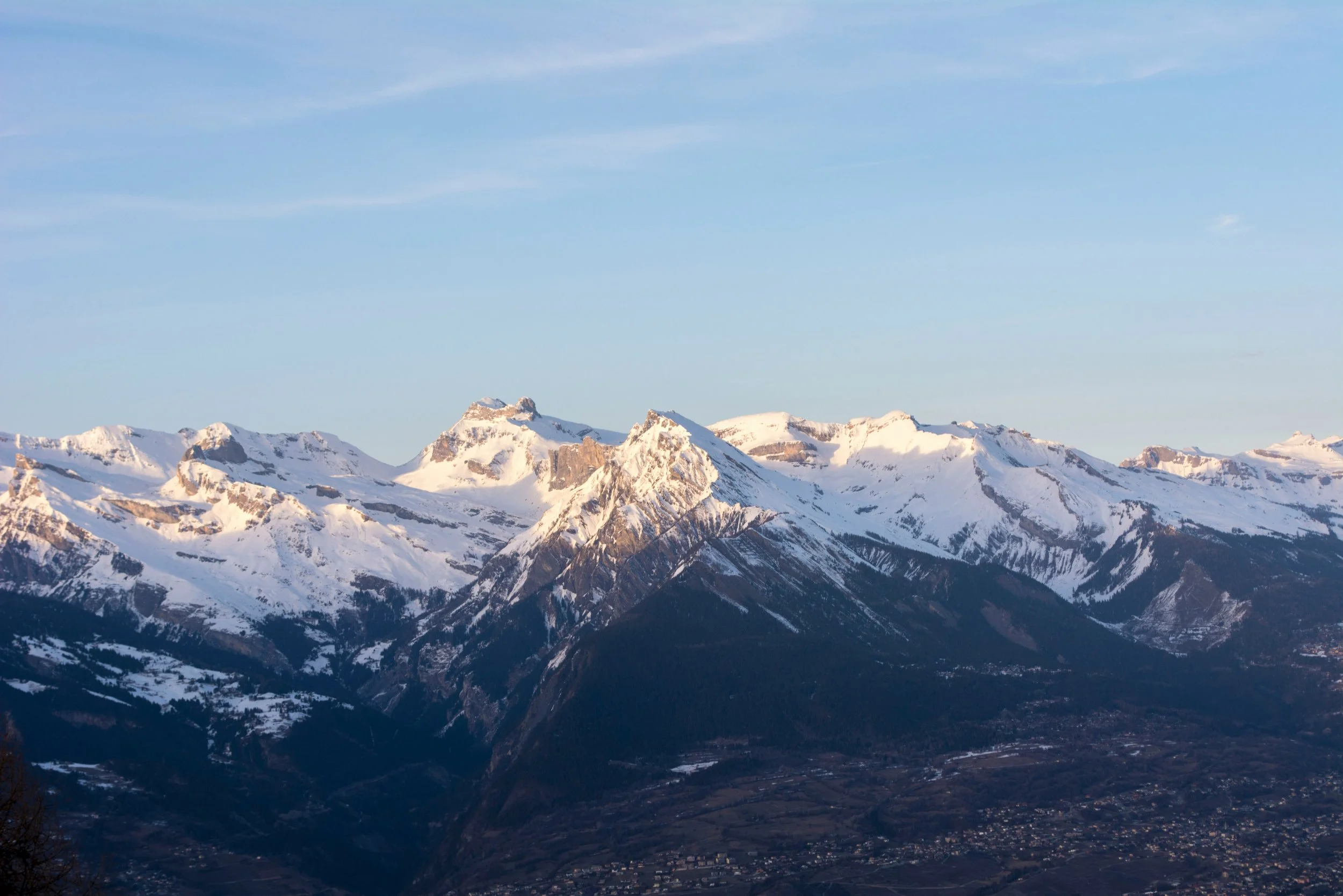Paysage montagneux avec sommets enneigés et ciel clair.