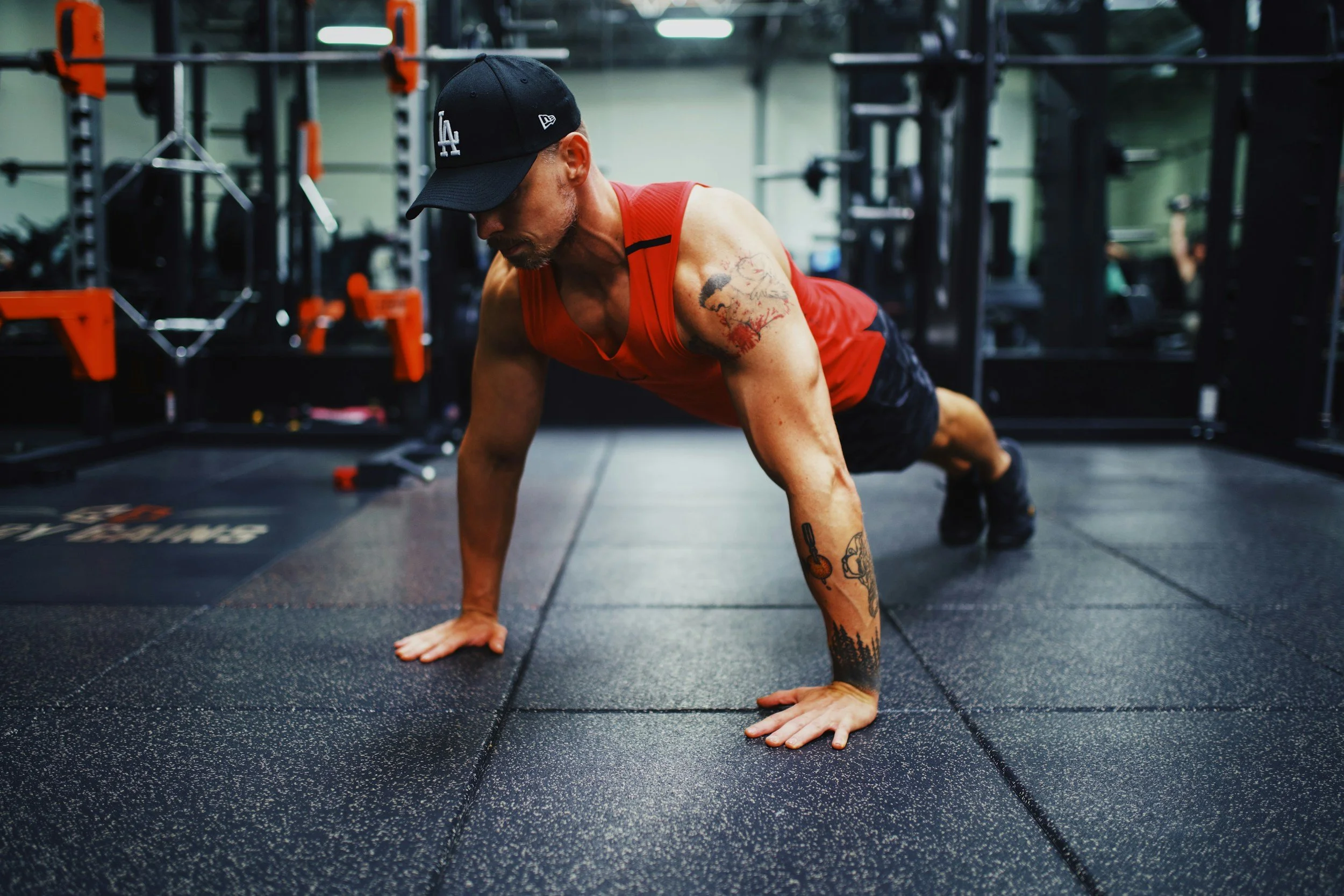 Man in red tank top performing push-up