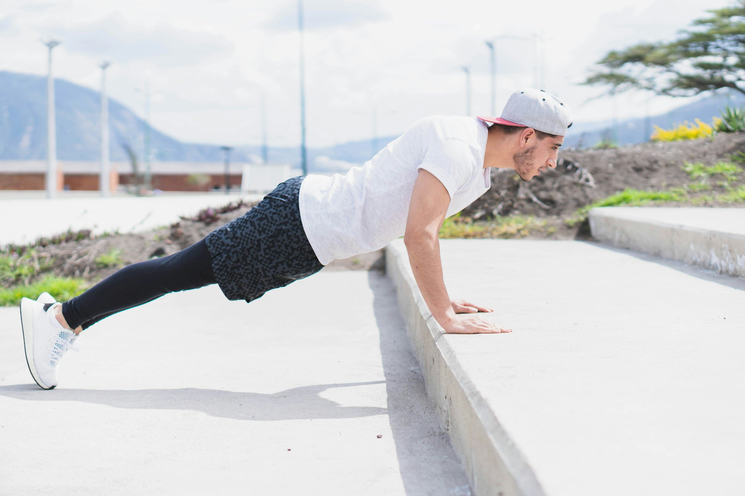 man performing incline push-up outdoors on stairs